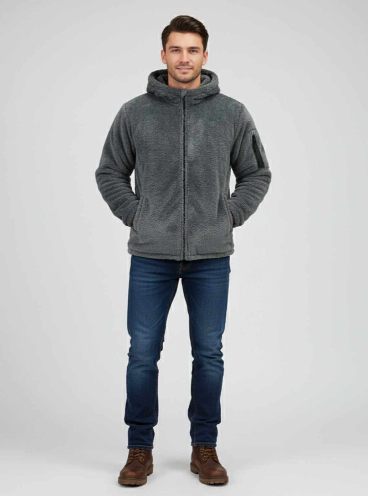 Man wearing a gray hoodie, blue jeans, and brown boots on a white background