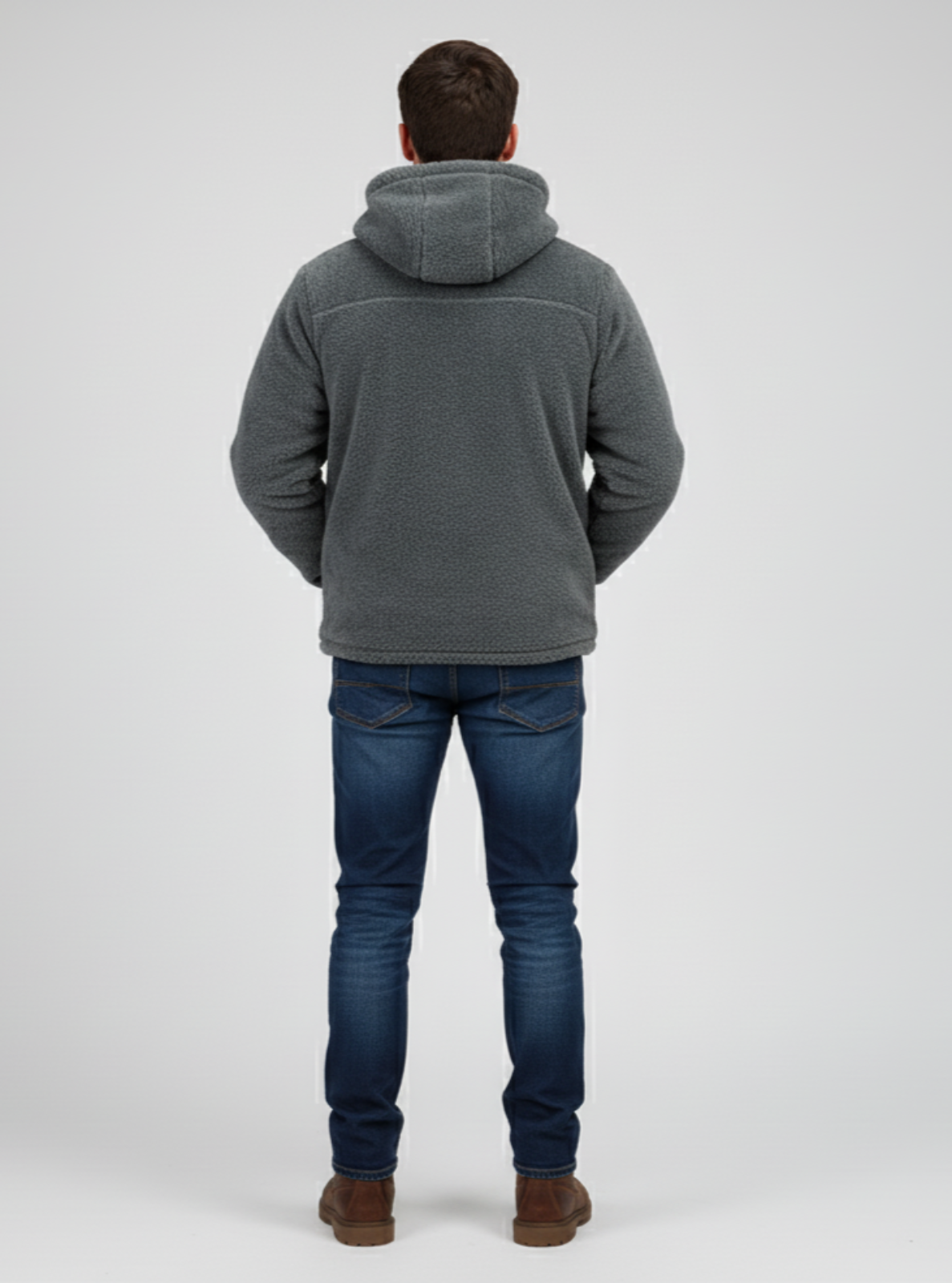 Person wearing a gray hoodie and blue jeans on a white background