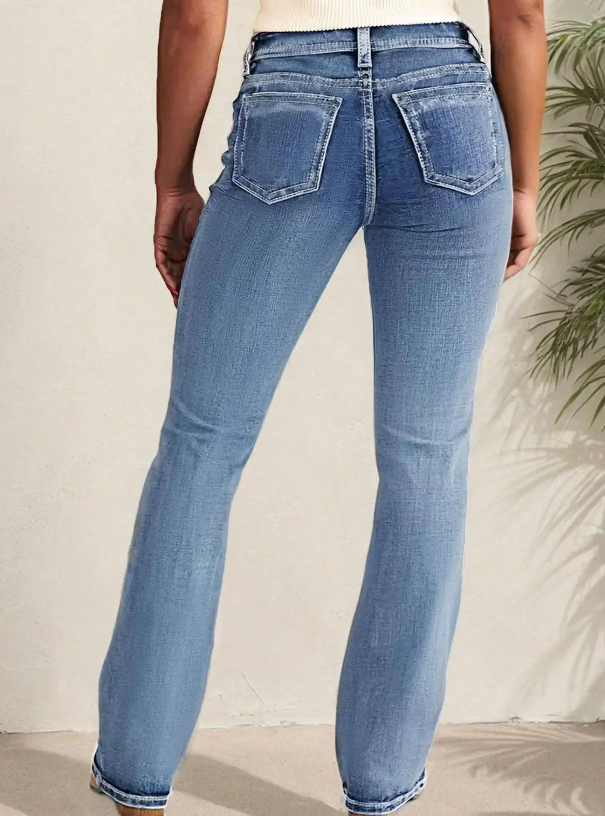 Person wearing blue jeans with a neutral background