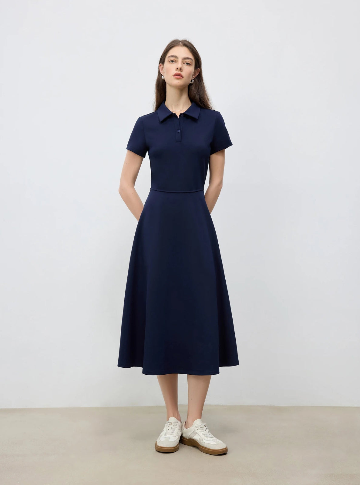 Woman wearing a navy dress with a white background