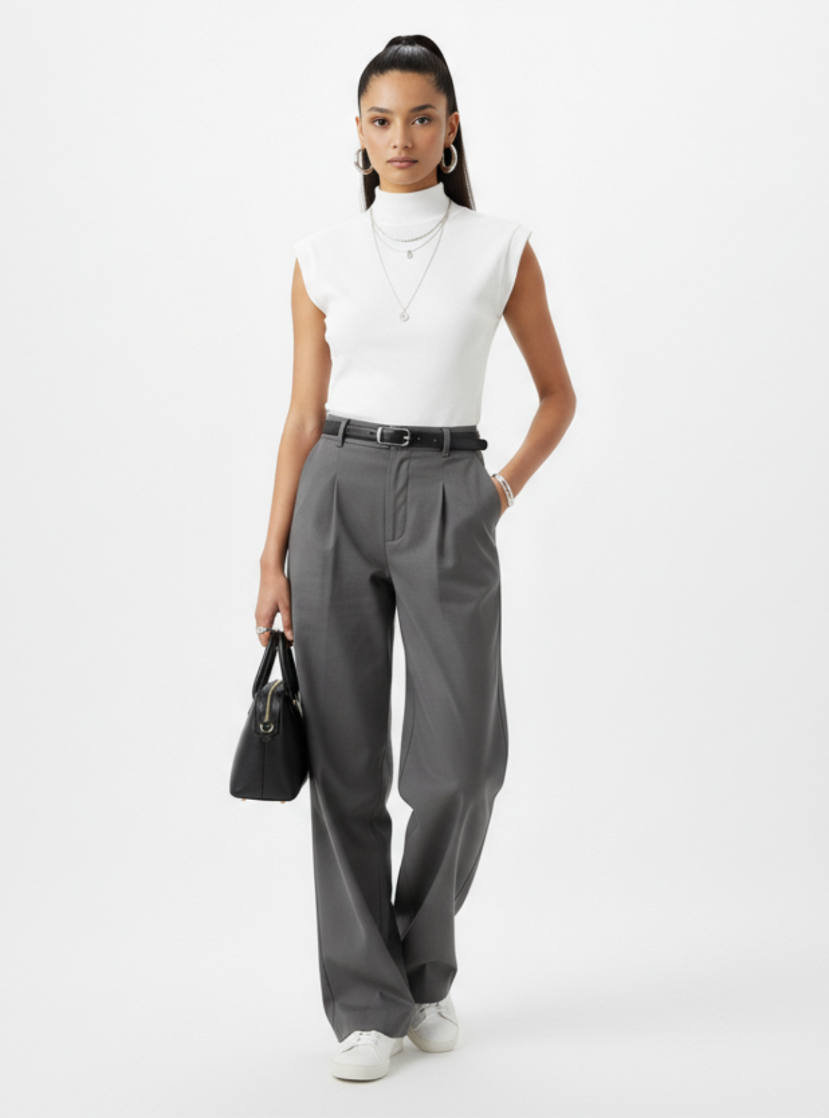Woman wearing a white top and gray pants on a white background