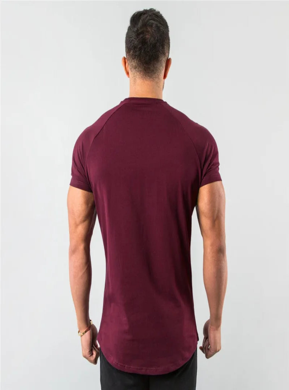 Man wearing a wine red t-shirt on a light gray background