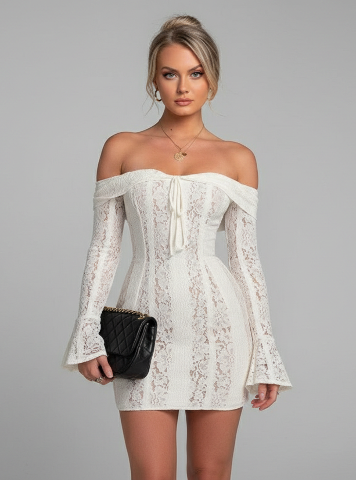 Woman wearing a white lace off-shoulder dress on a gray background