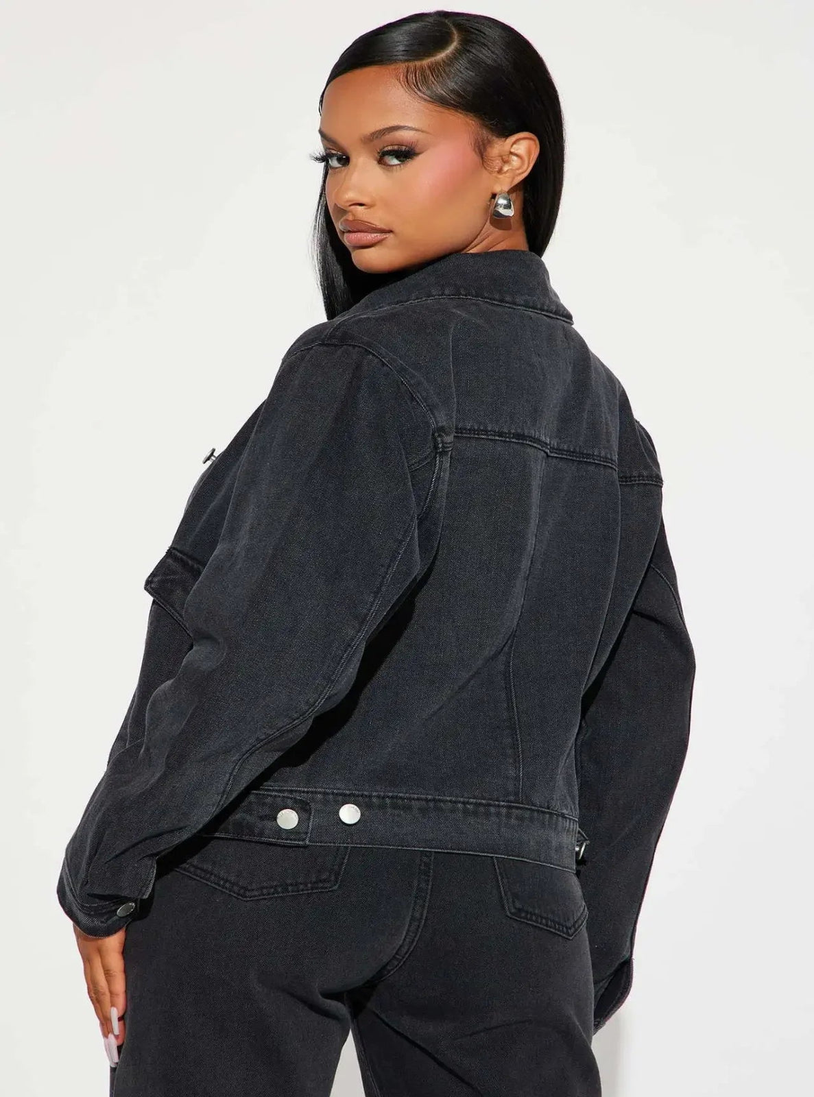 Woman wearing a black denim jacket on a white background