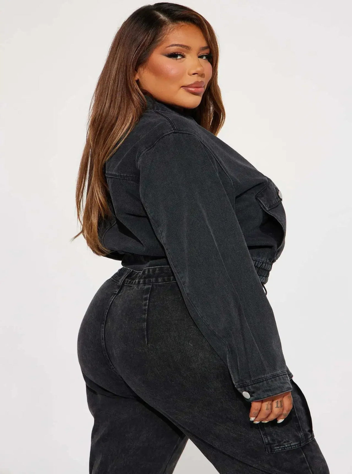 Woman wearing a black denim outfit on a white background