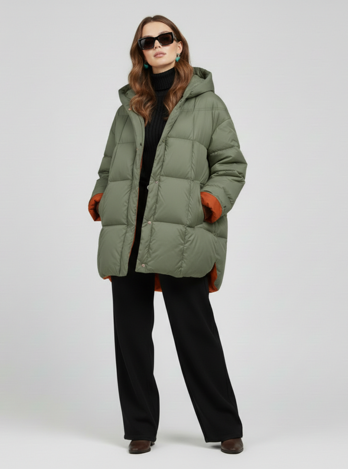 Woman wearing a green puffer coat on a white background