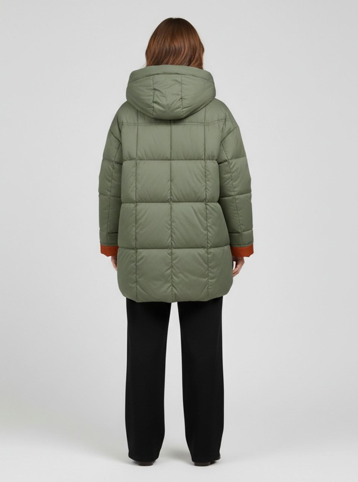Person wearing a green puffer coat on a white background