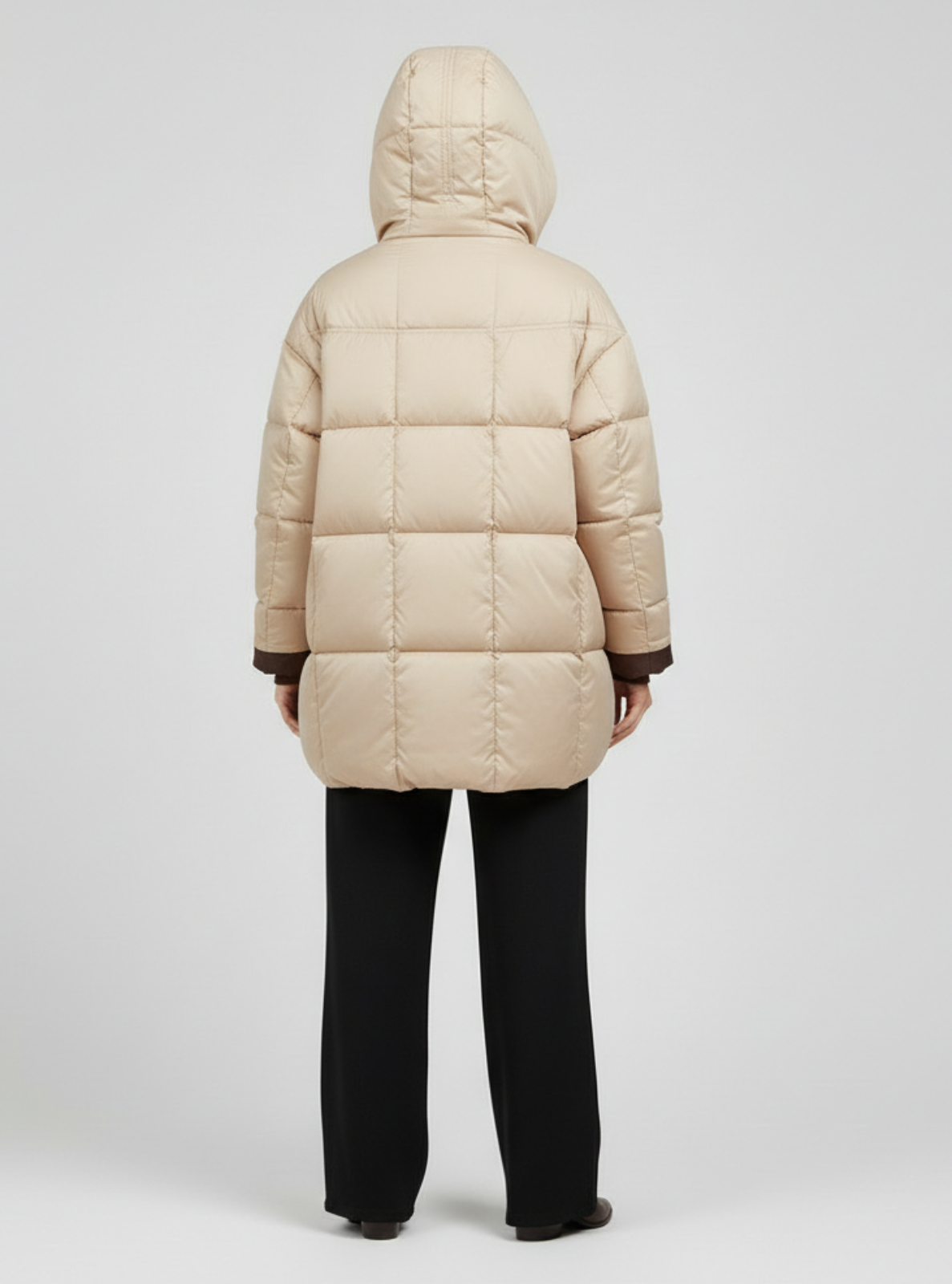 Beige puffer jacket worn by a person on a light gray background