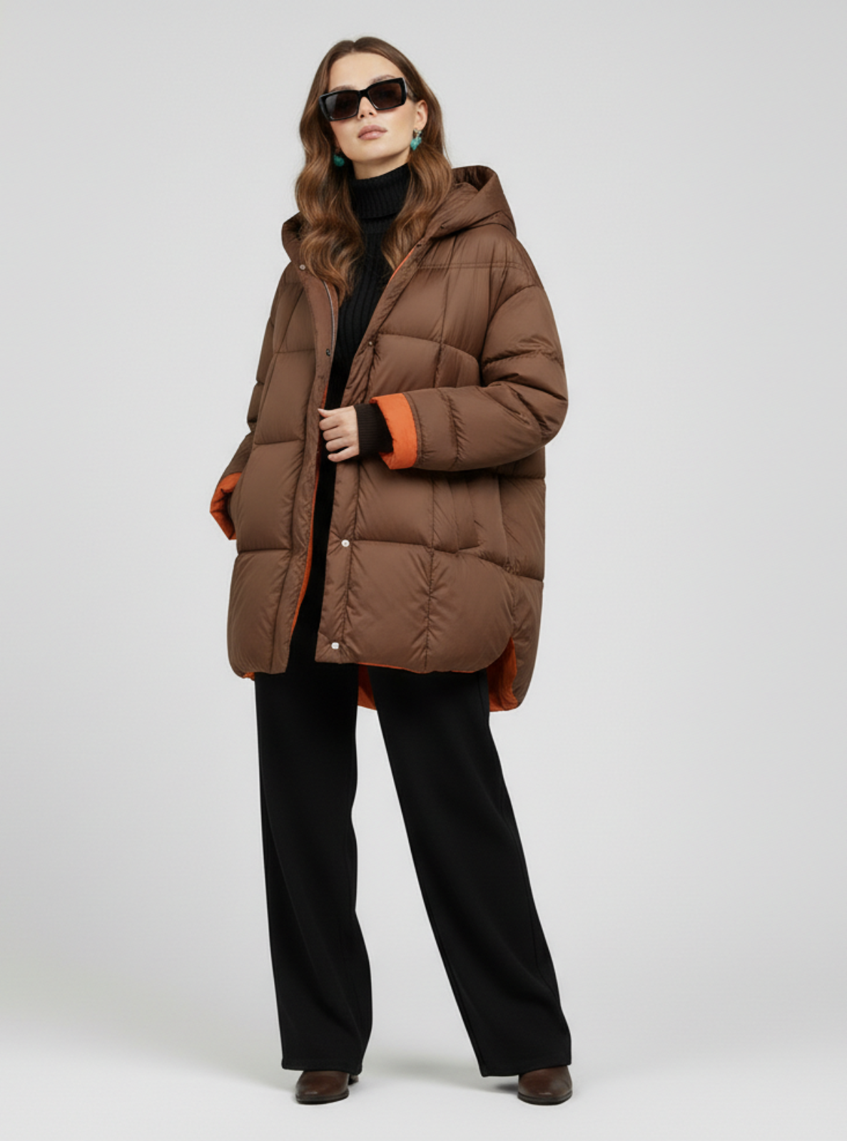 Woman wearing a brown puffer coat on a white background