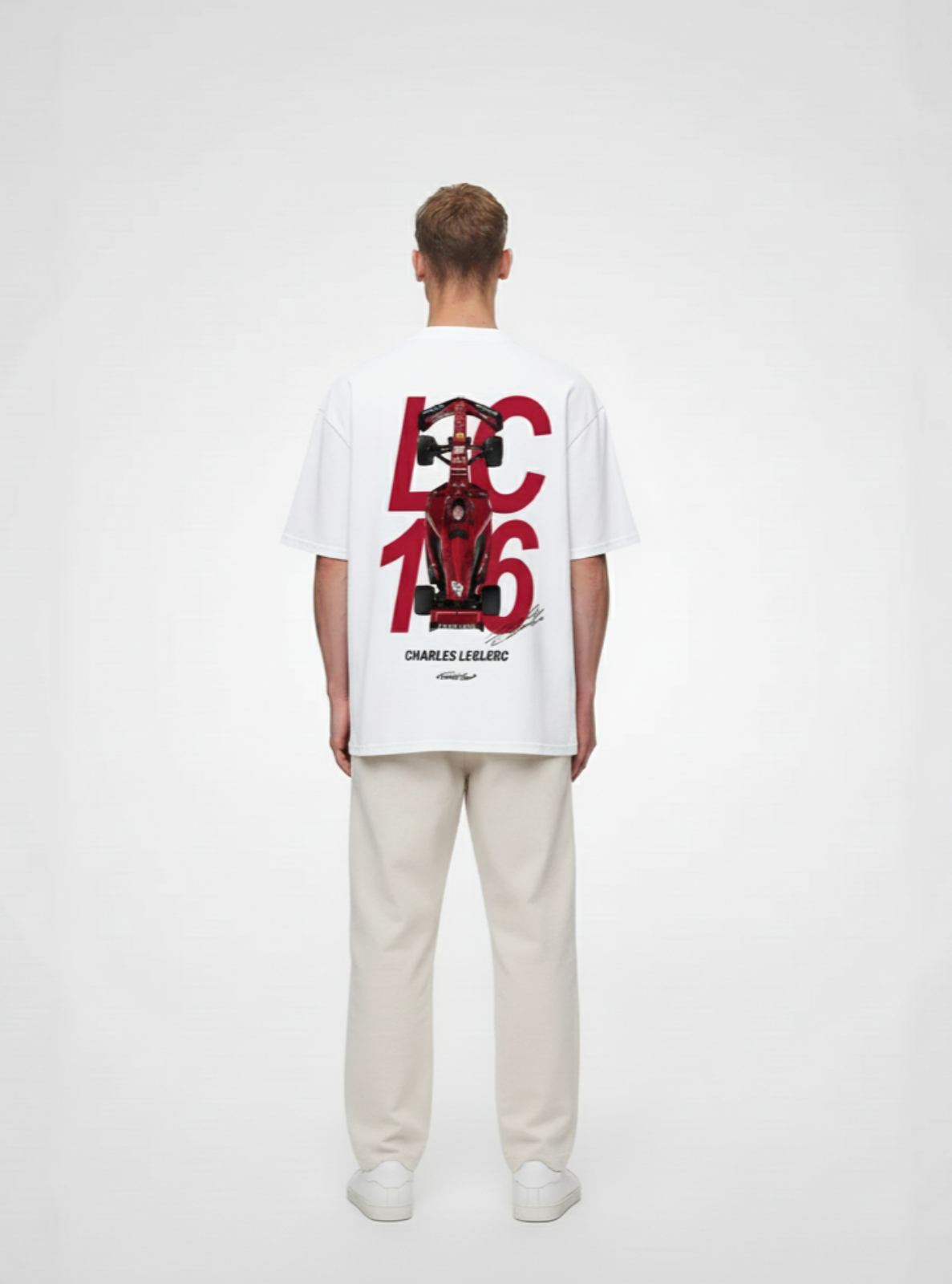 Person wearing a white t-shirt with red and black graphics on the back, standing against a plain background