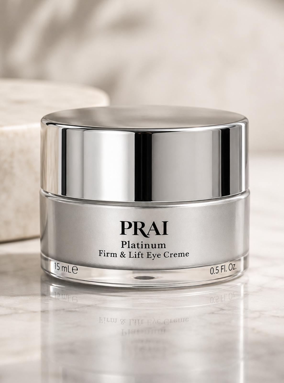 PRAI Platinum Firm & Lift Eye Creme in a silver jar with a reflective lid, set on a polished marble surface with a soft-focus background.