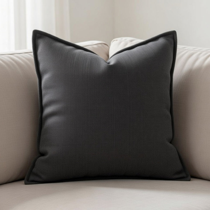 Gray pillow on a beige sofa with a neutral background