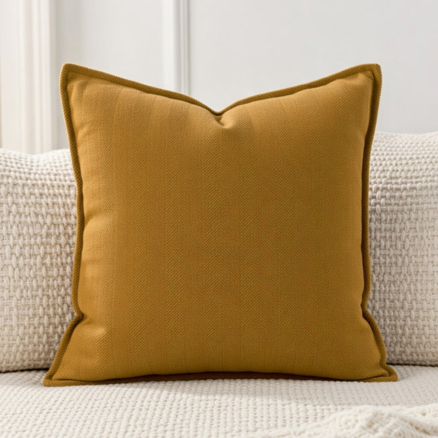 Mustard yellow pillow on a beige sofa with a neutral background