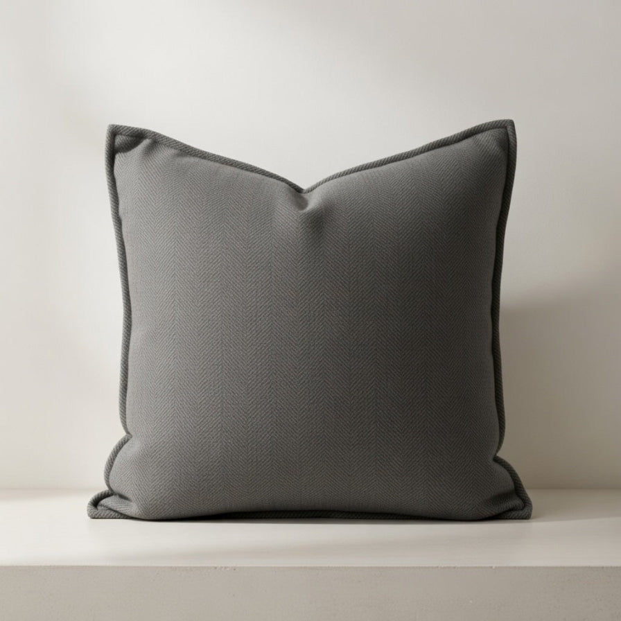 Gray pillow on a white surface with a neutral background