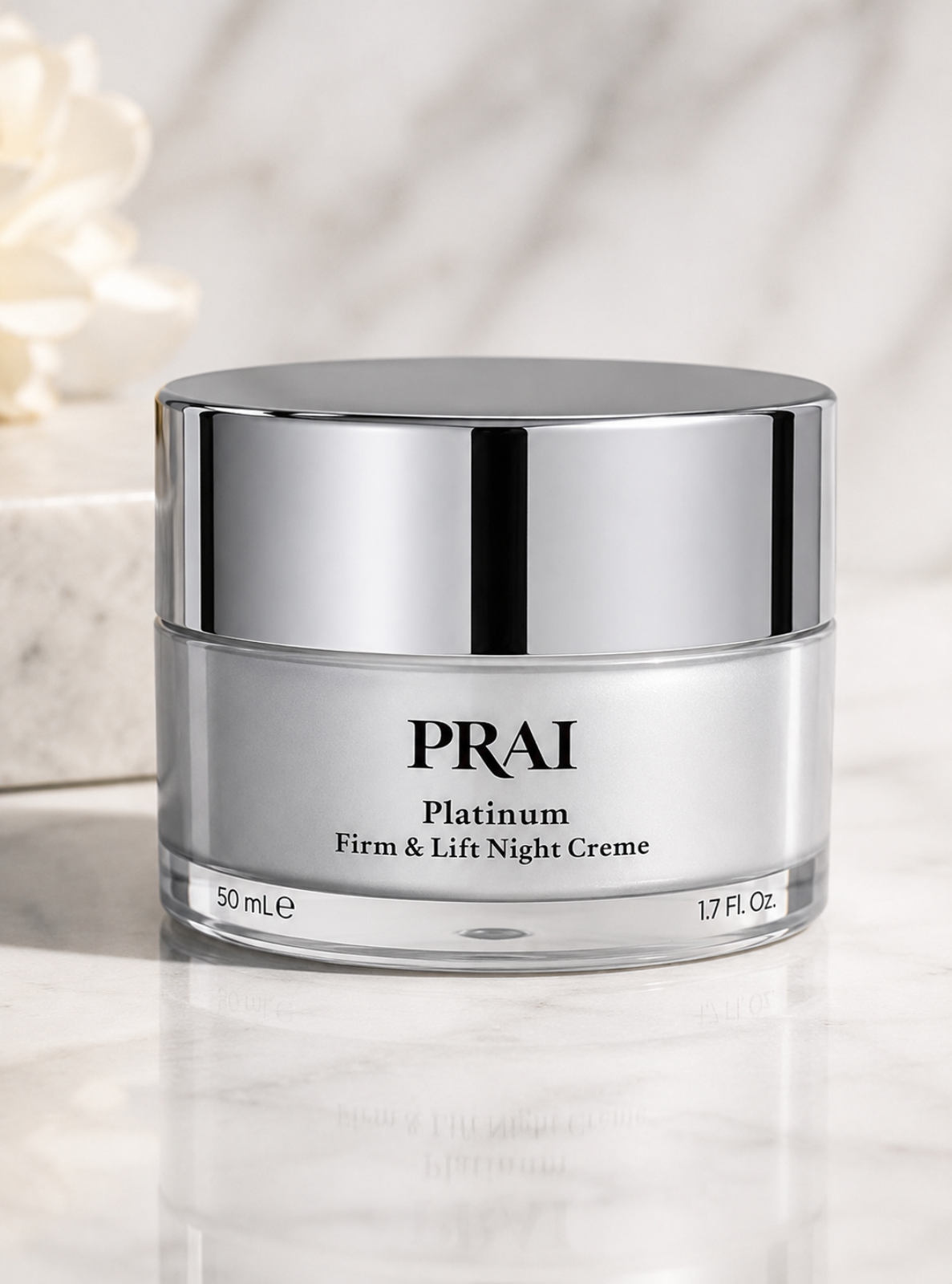 A silver jar of PRAI Platinum Firm & Lift Night Creme on a light marble surface with a soft blurred background.