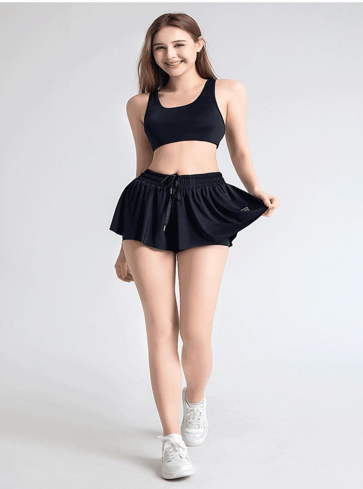 Woman wearing a black athletic outfit on a white background