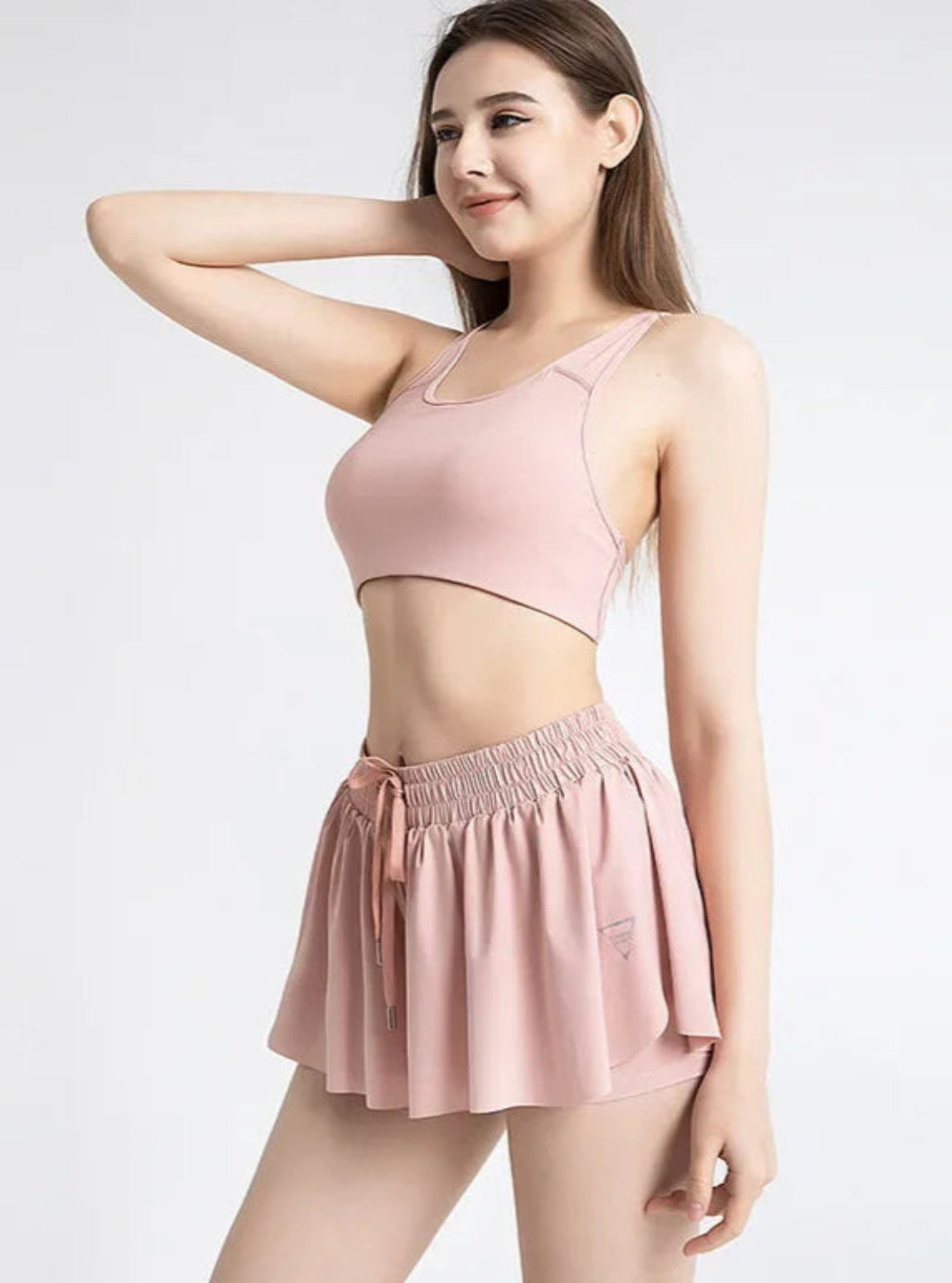 Woman wearing a pink athletic outfit on a white background