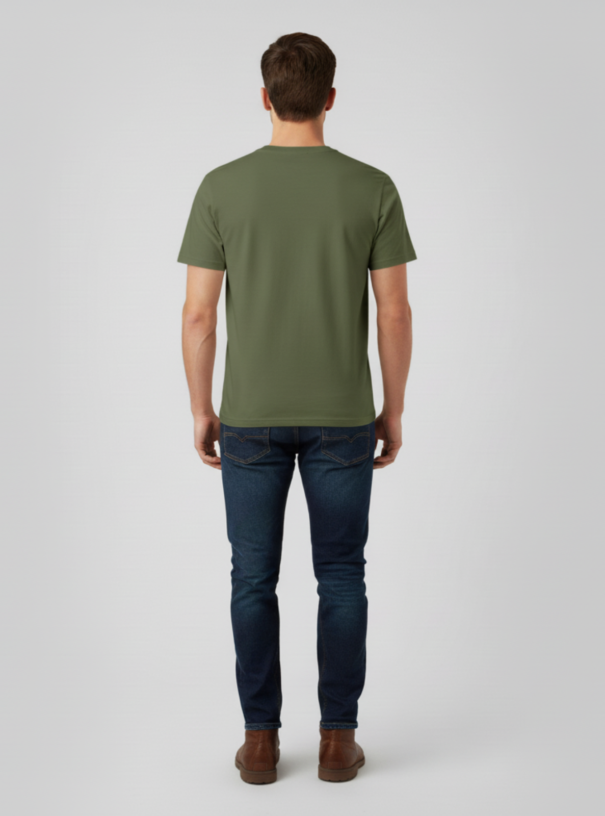 Man wearing a green t-shirt and dark jeans on a light gray background