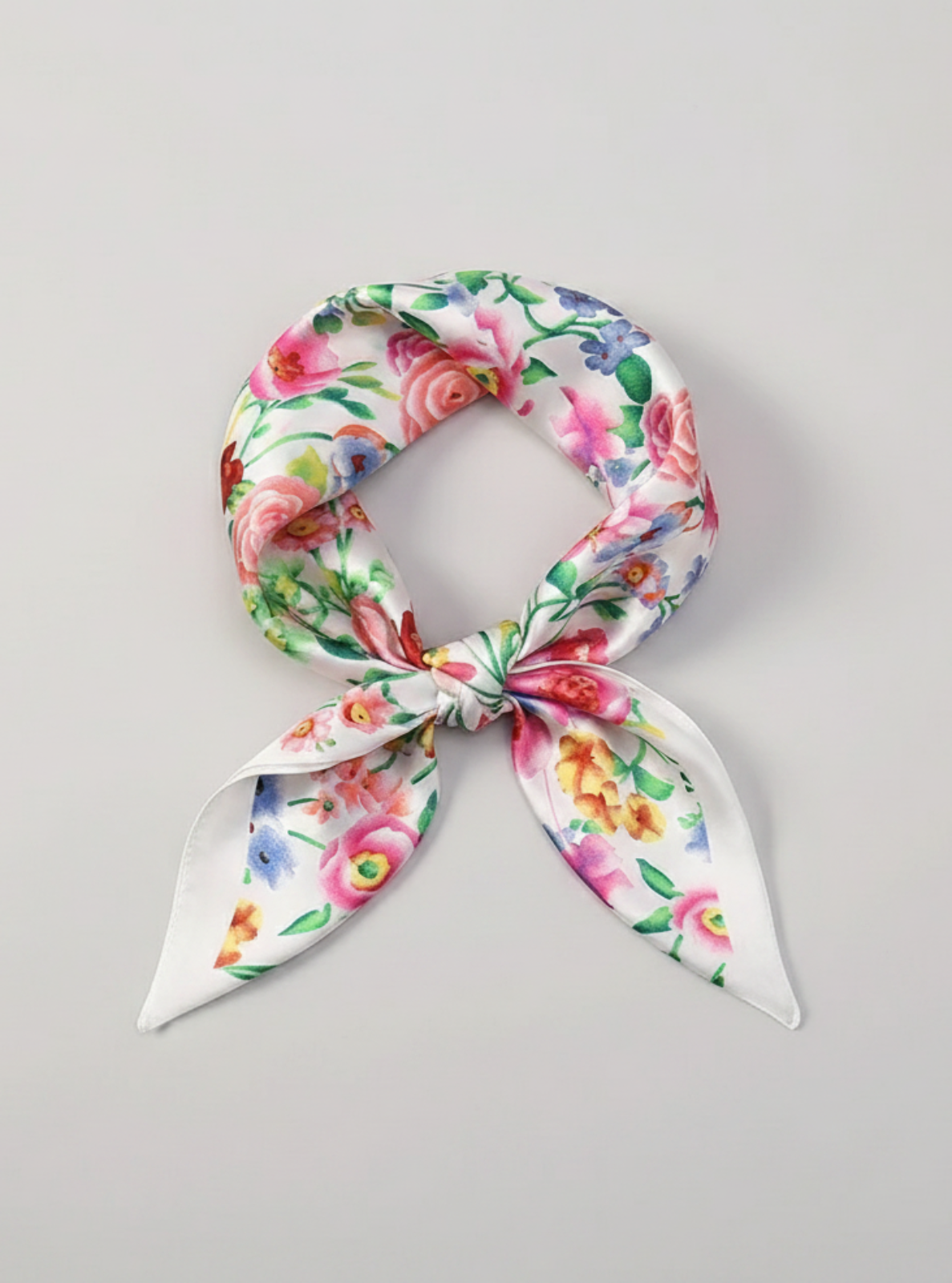 Floral patterned scarf tied on a gray background