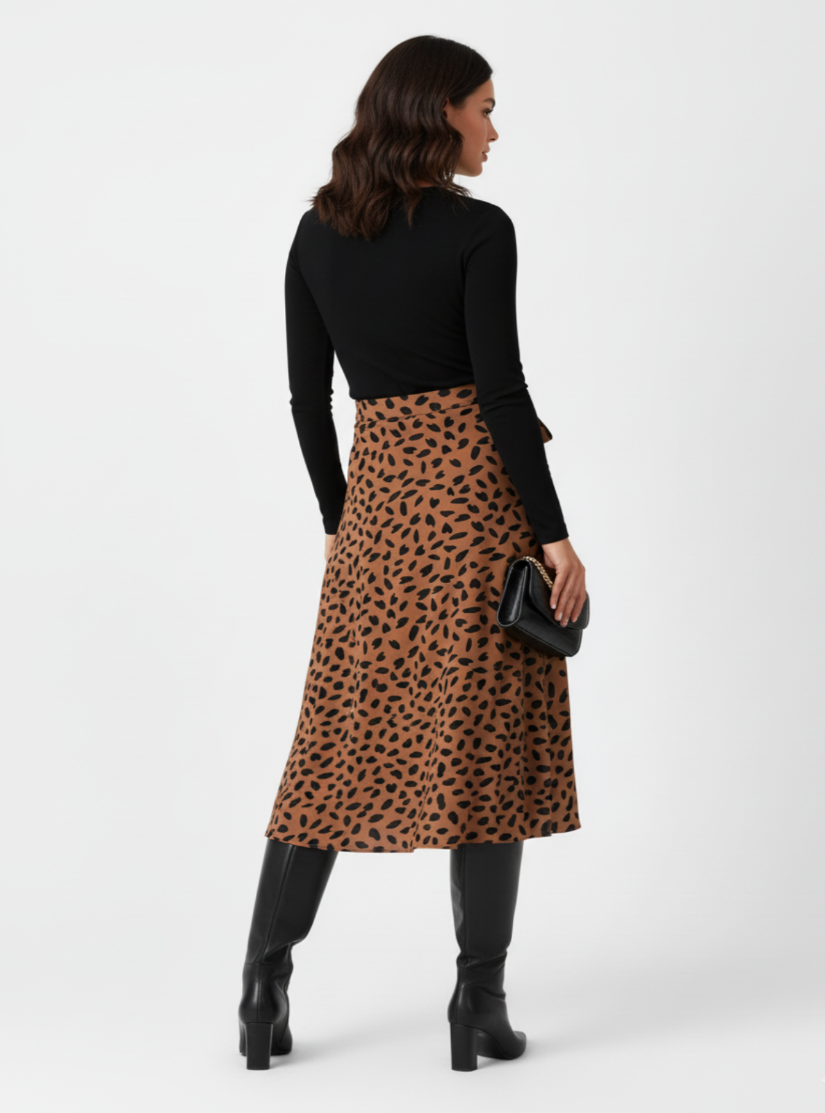 Woman wearing a black top and leopard print skirt on a white background