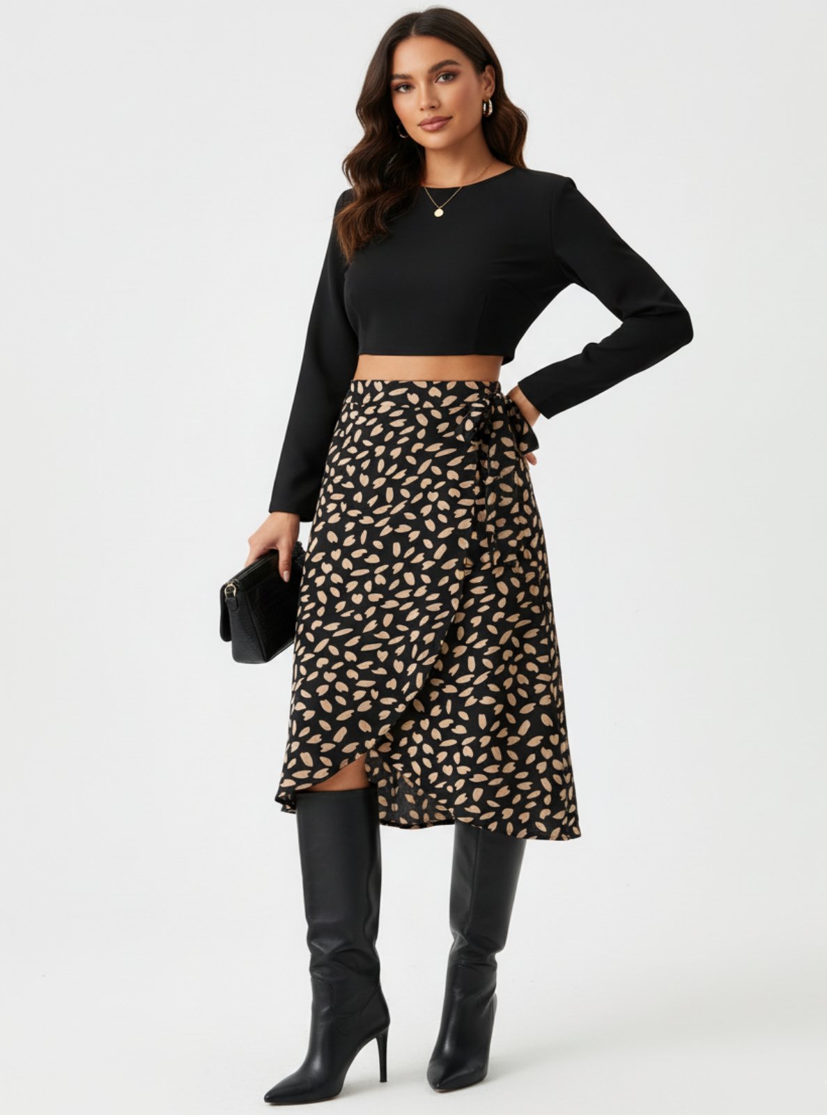 Woman wearing a black long-sleeve top and patterned skirt with black knee-high boots on a white background