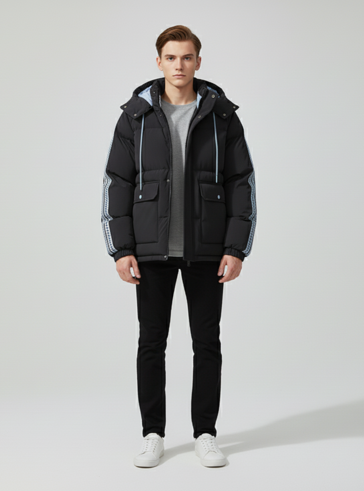 Man wearing a black winter jacket with white accents on a light gray background