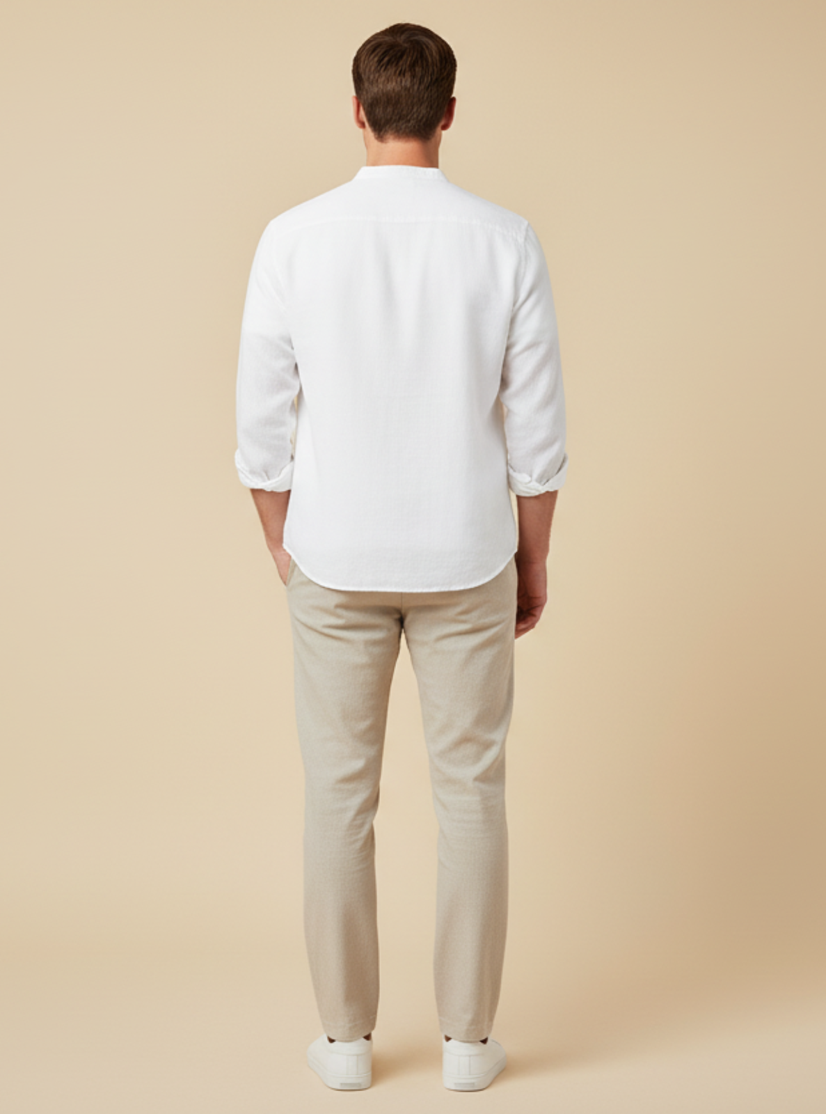 Man wearing a white shirt and beige pants against a beige background