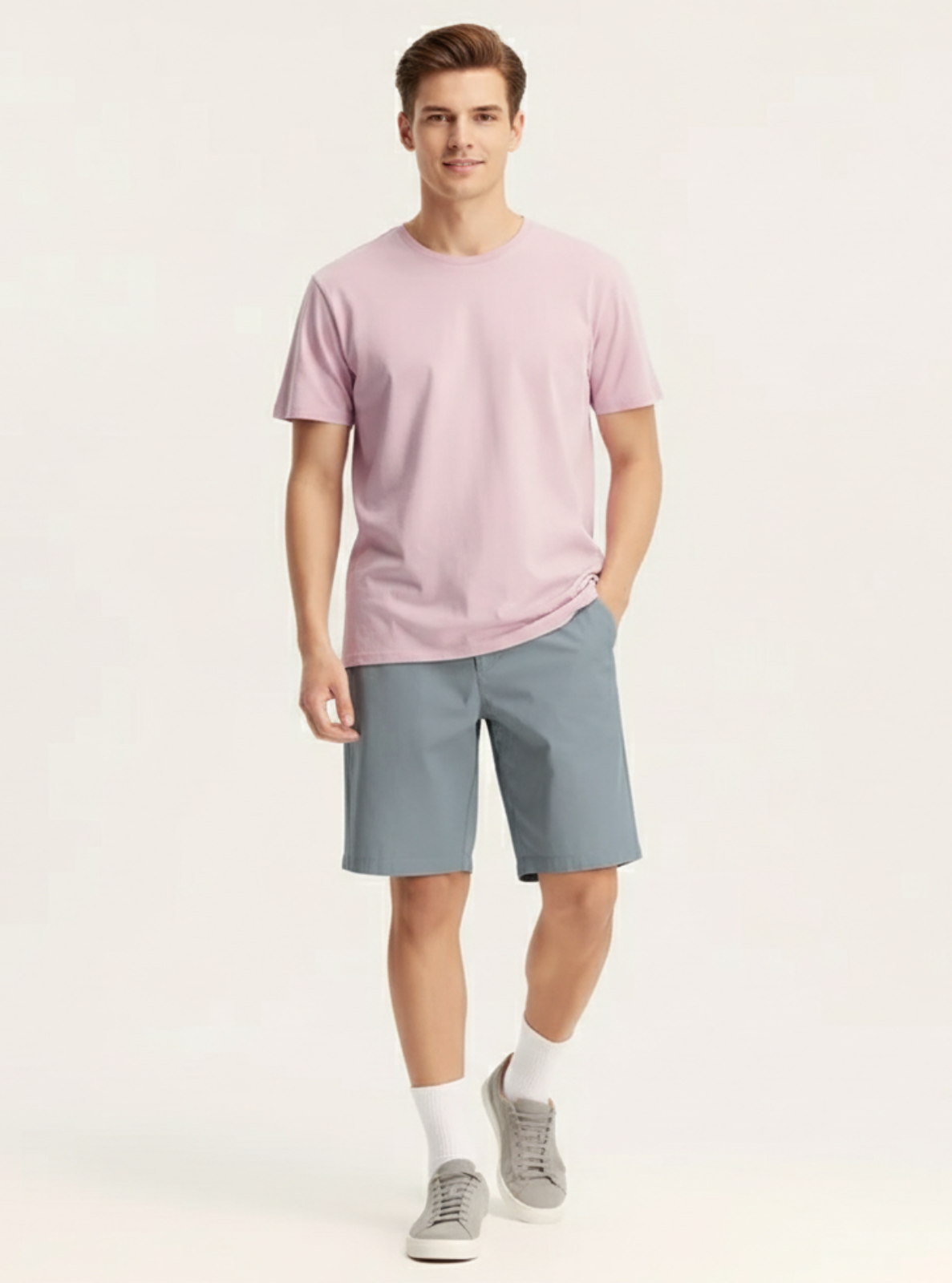 Man wearing a pink t-shirt and gray shorts on a white background