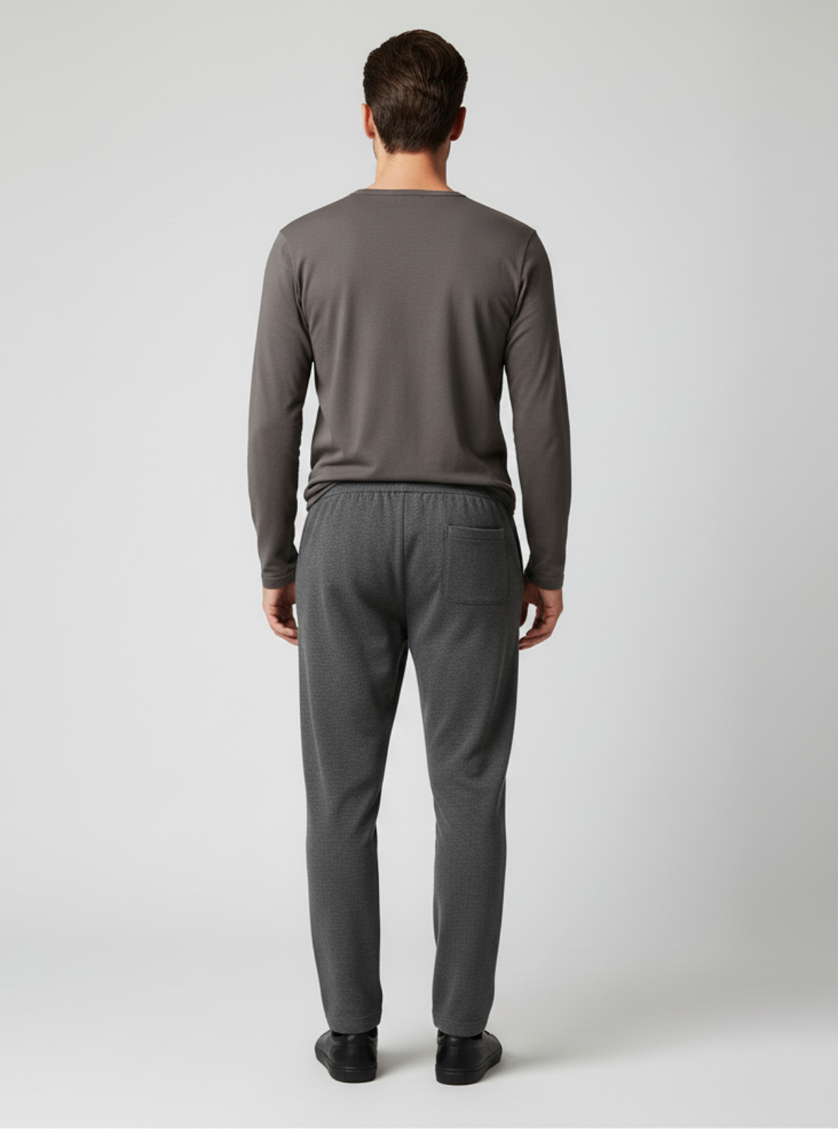 Man wearing a gray long-sleeve shirt and pants on a white background