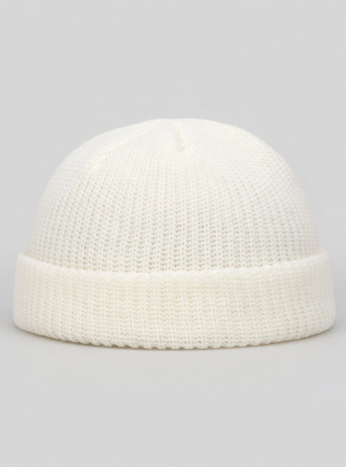 White knit beanie on a light gray background