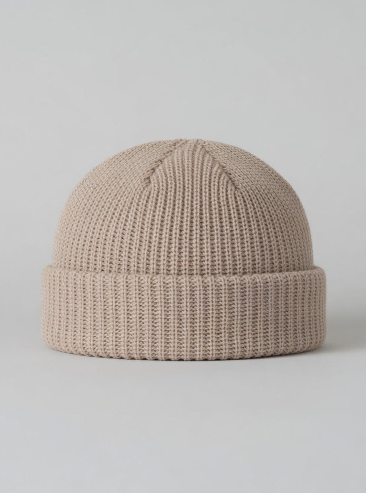 Beige knit beanie on a light gray background