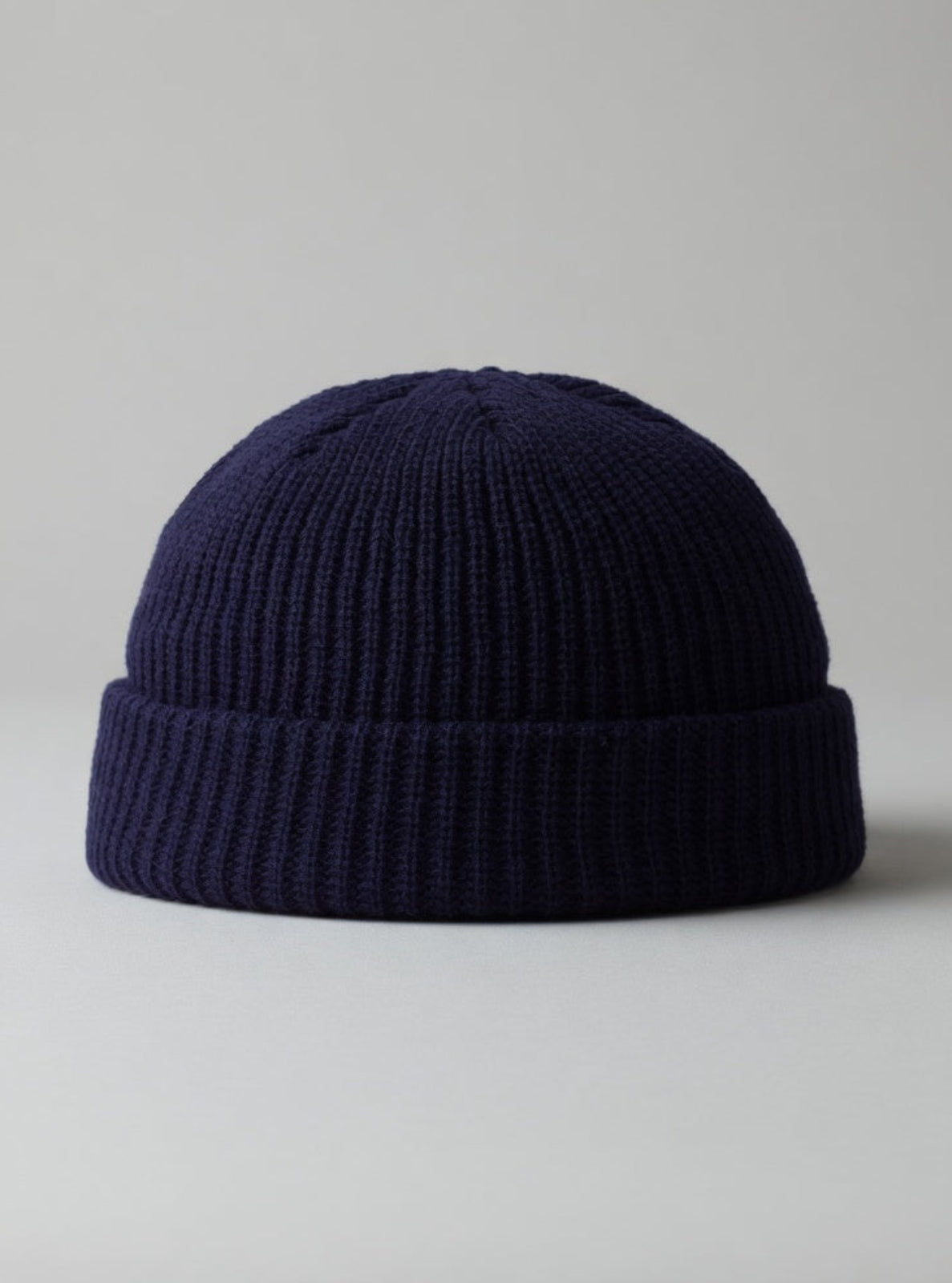 Navy blue knit beanie on a light gray background