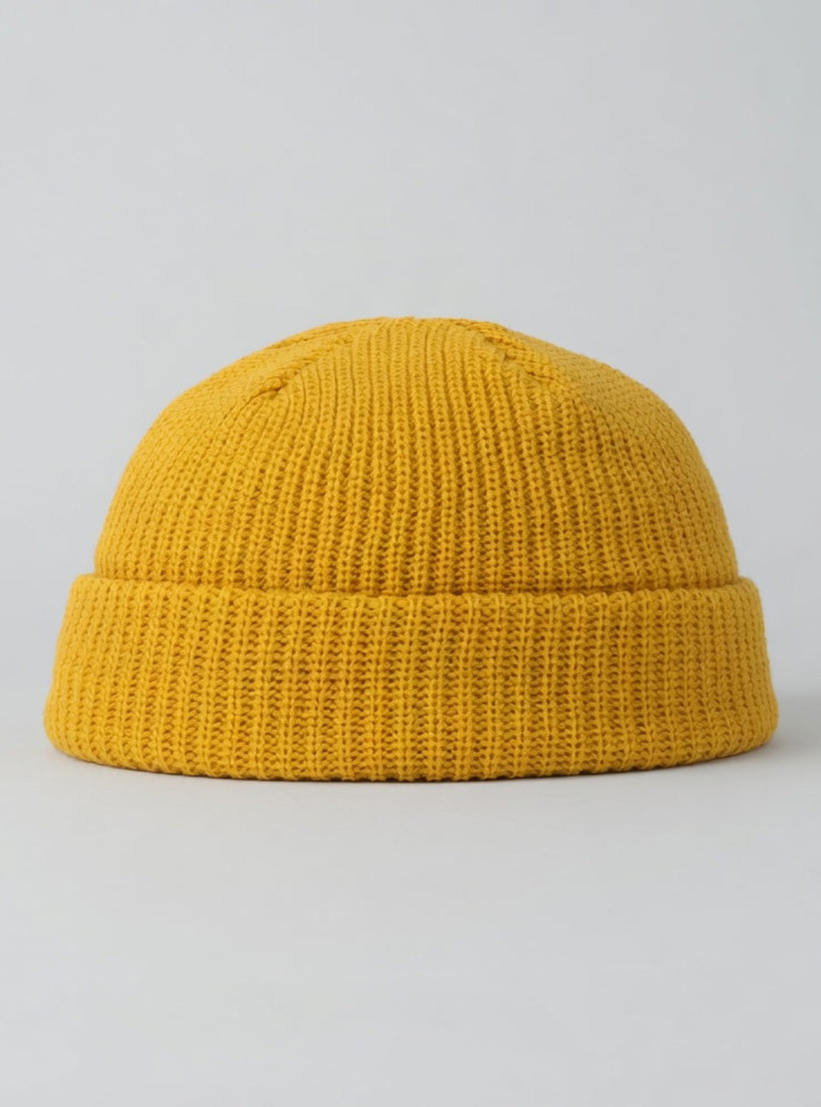 Yellow knit beanie on a light gray background