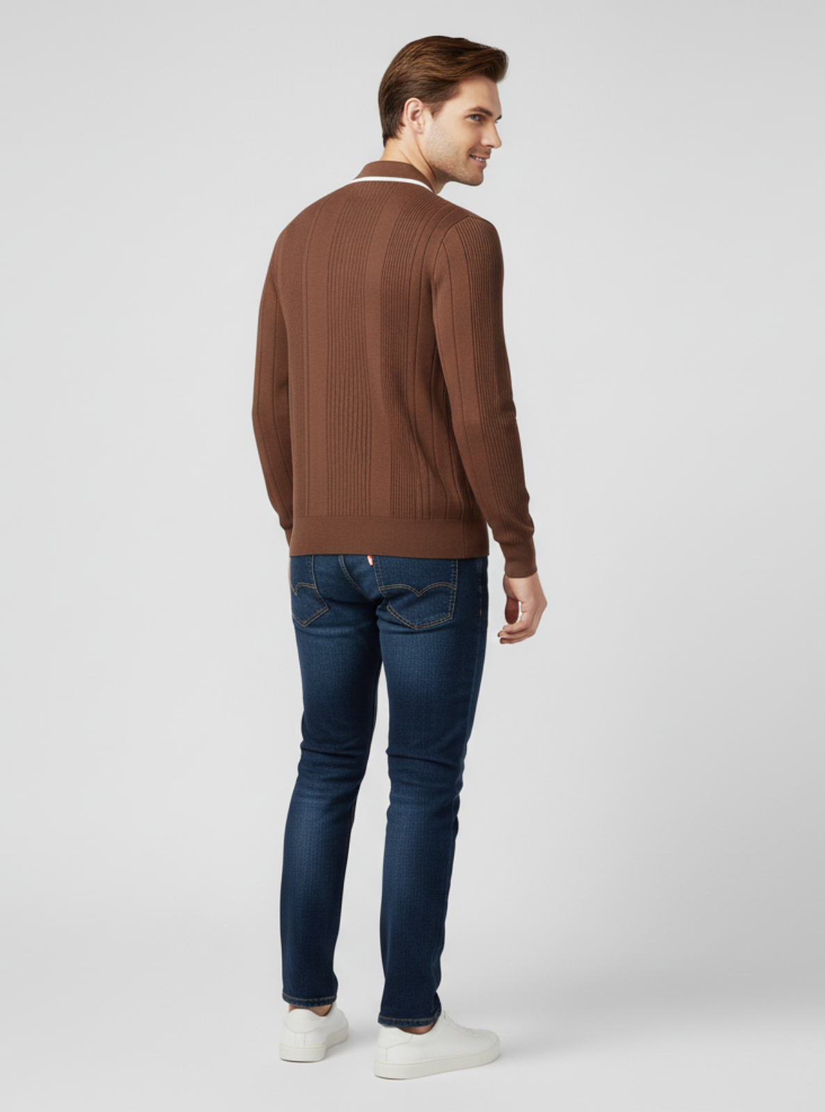 Man wearing a brown sweater and blue jeans on a white background