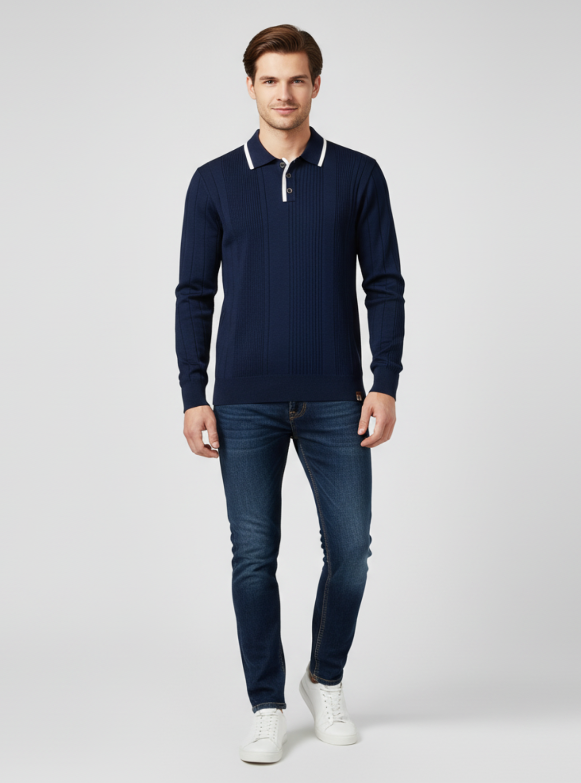 Man wearing a navy sweater and jeans on a white background