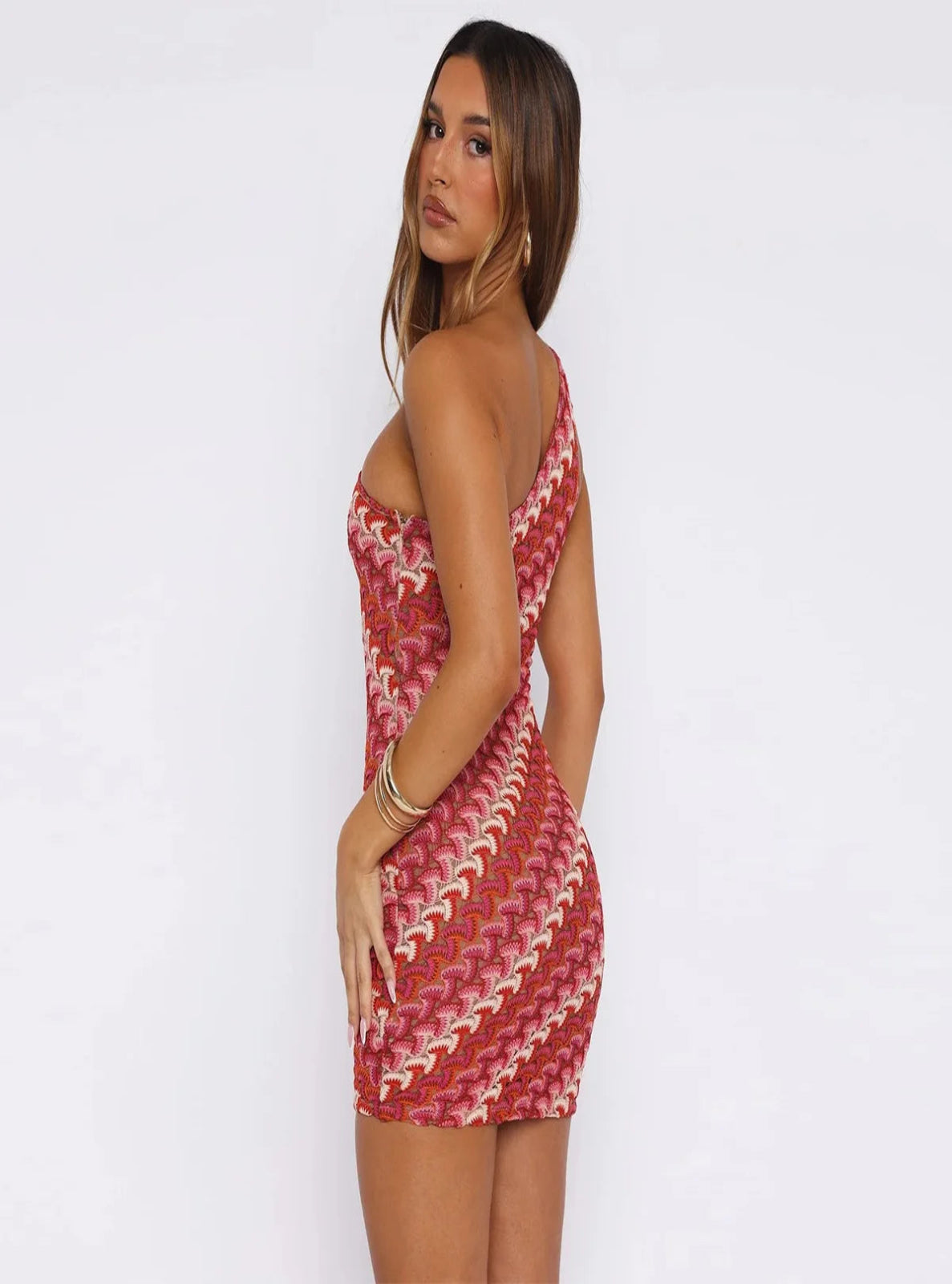 Woman wearing a patterned red and white dress against a plain background