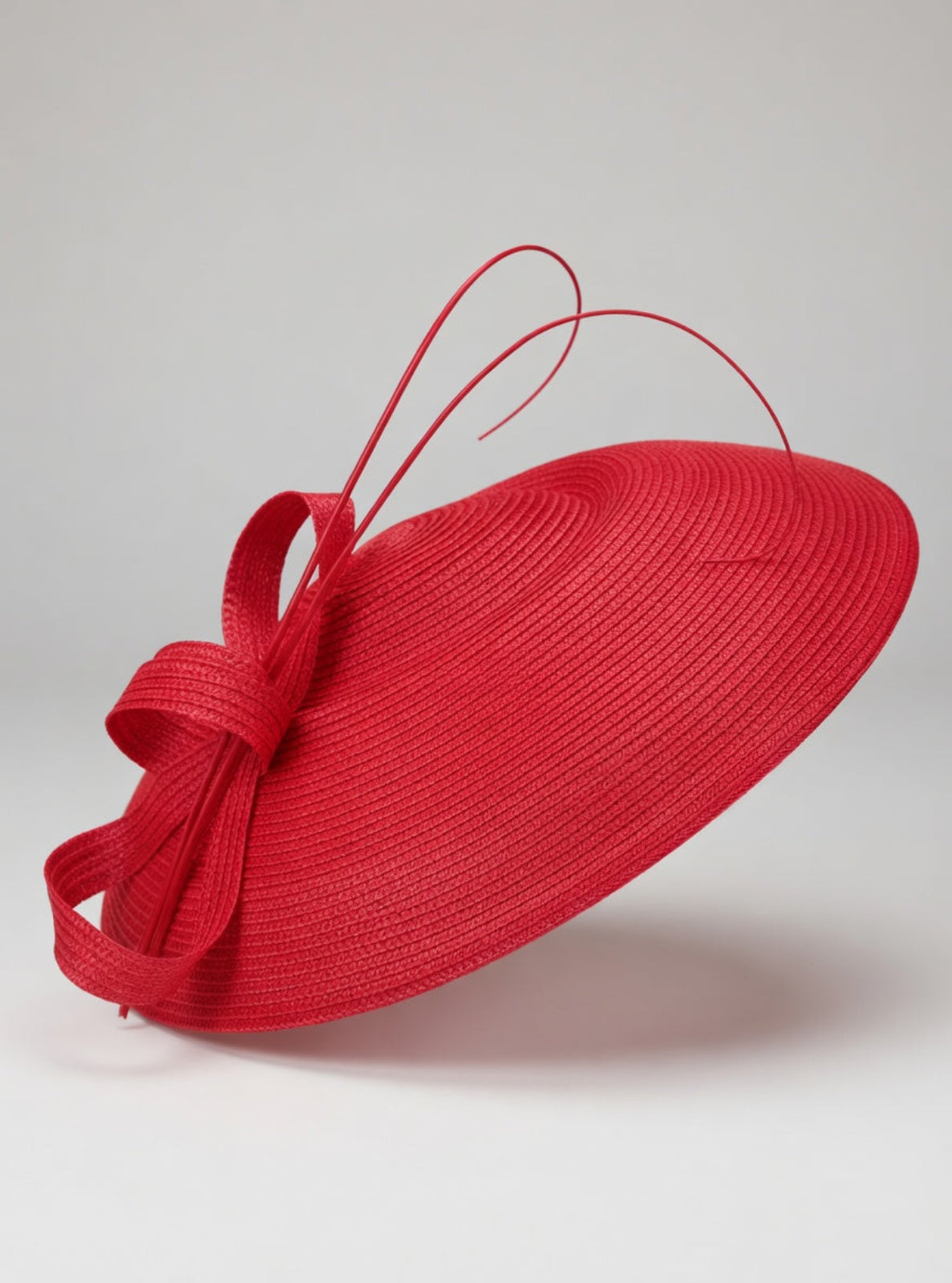 Red hat with a bow on a light gray background