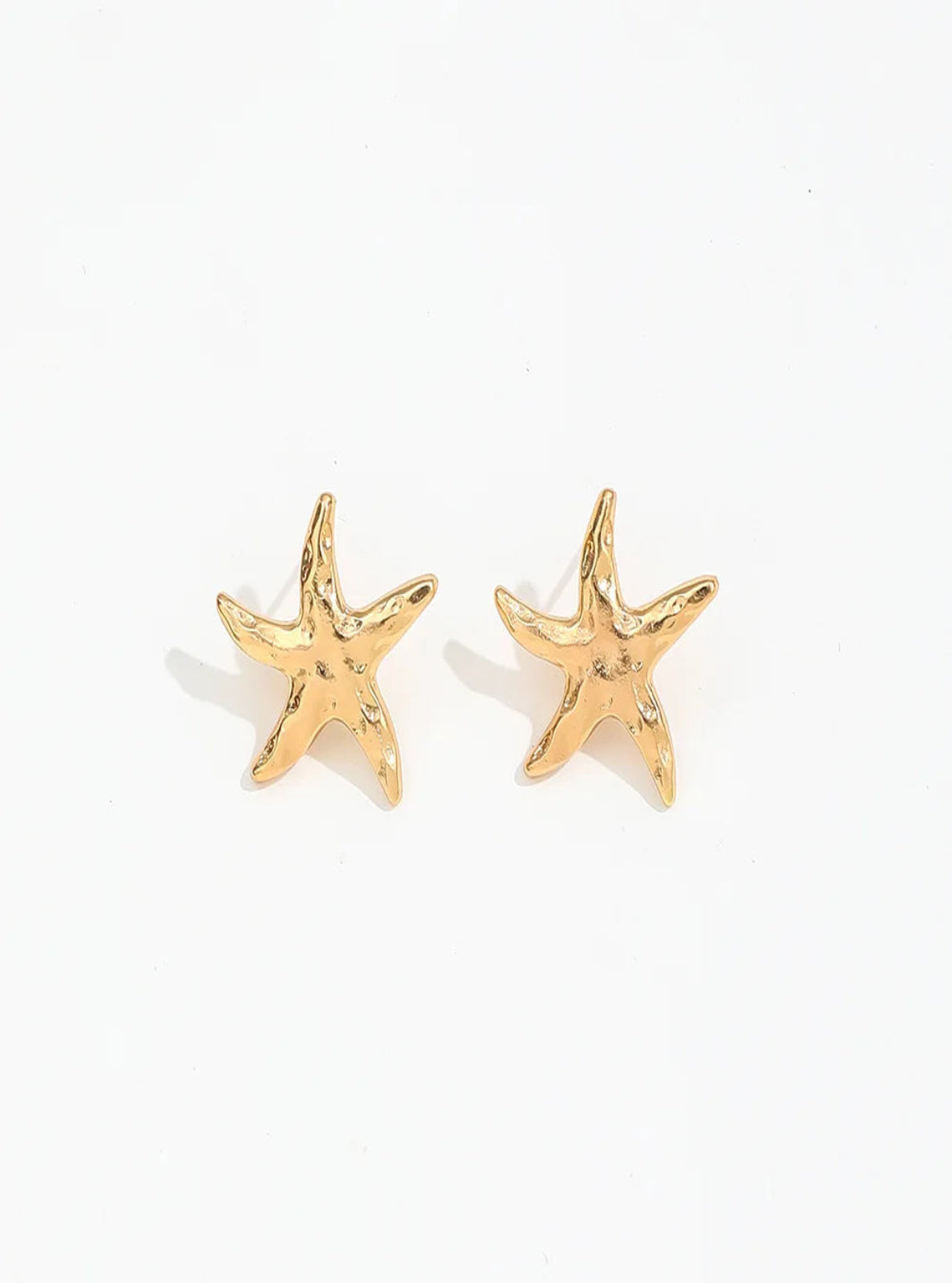 Gold starfish earrings on a white background