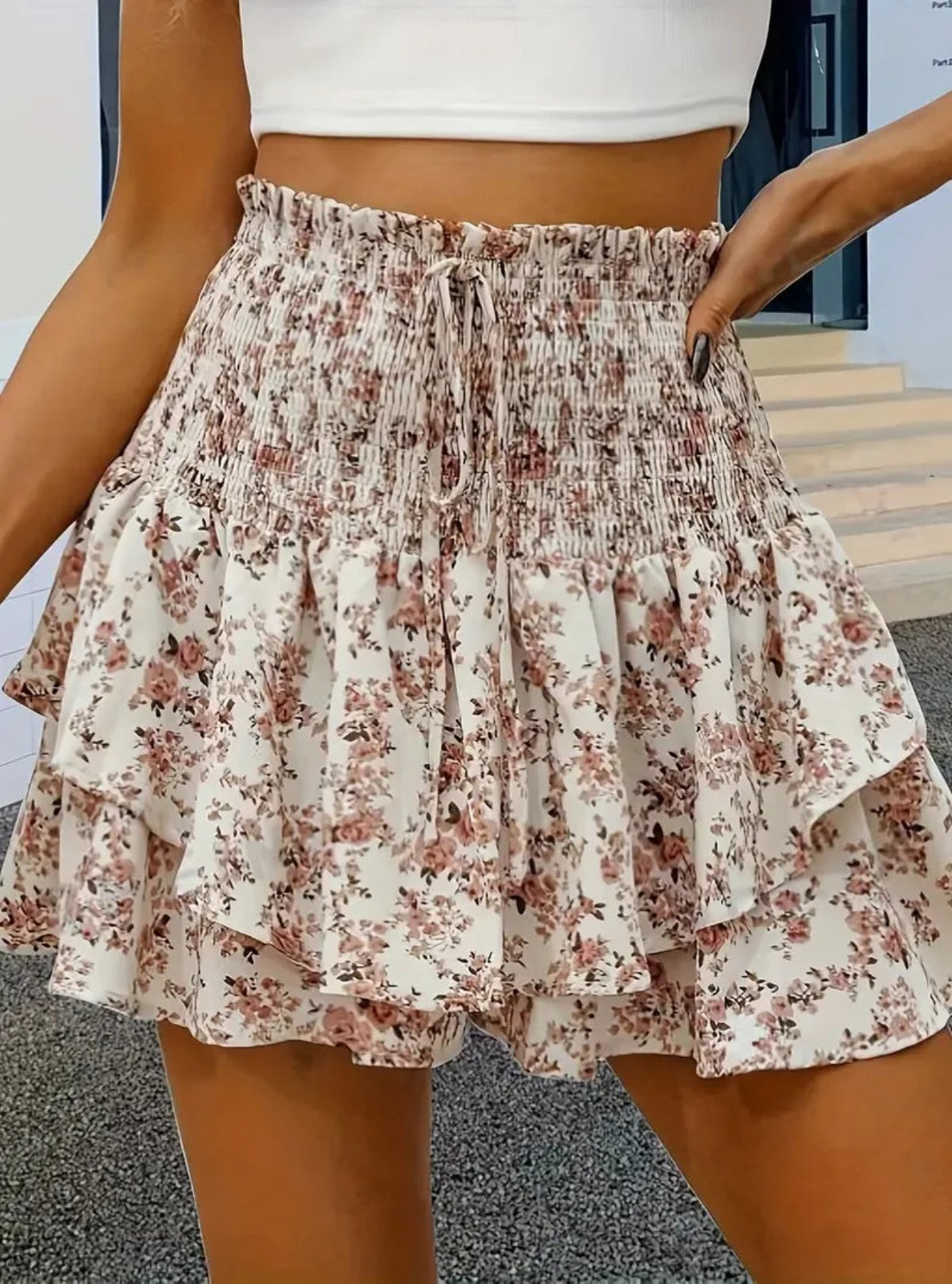 Floral tiered shorts worn by a person with a neutral background