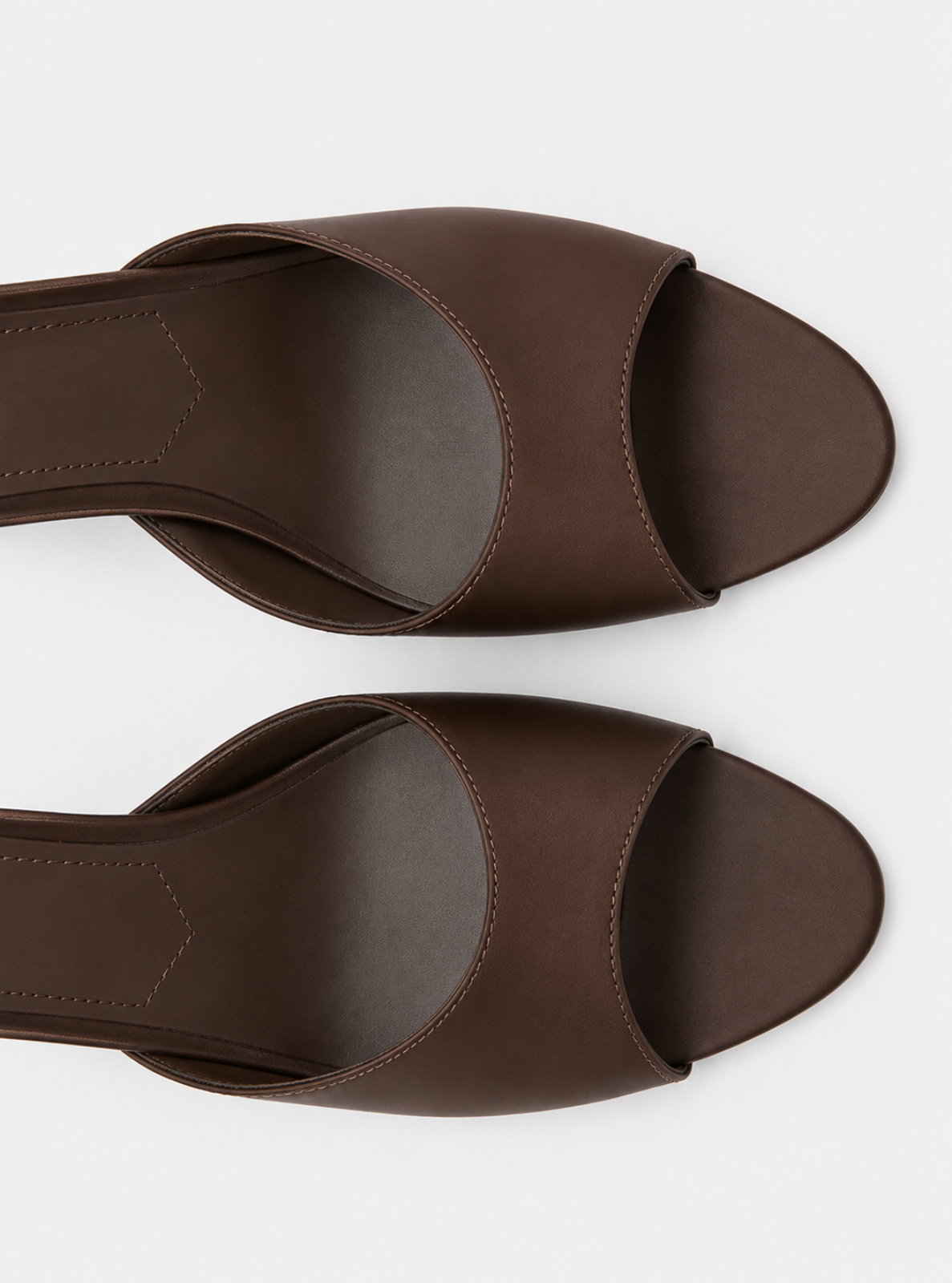 A pair of dark brown leather slide sandals with open toes and low block heels, shown from a top-down view on a light gray background.