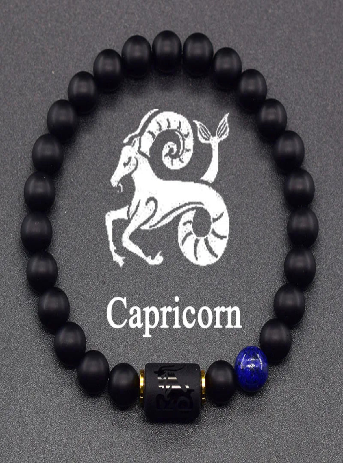Black beaded bracelet with Capricorn symbol and name on a gray background