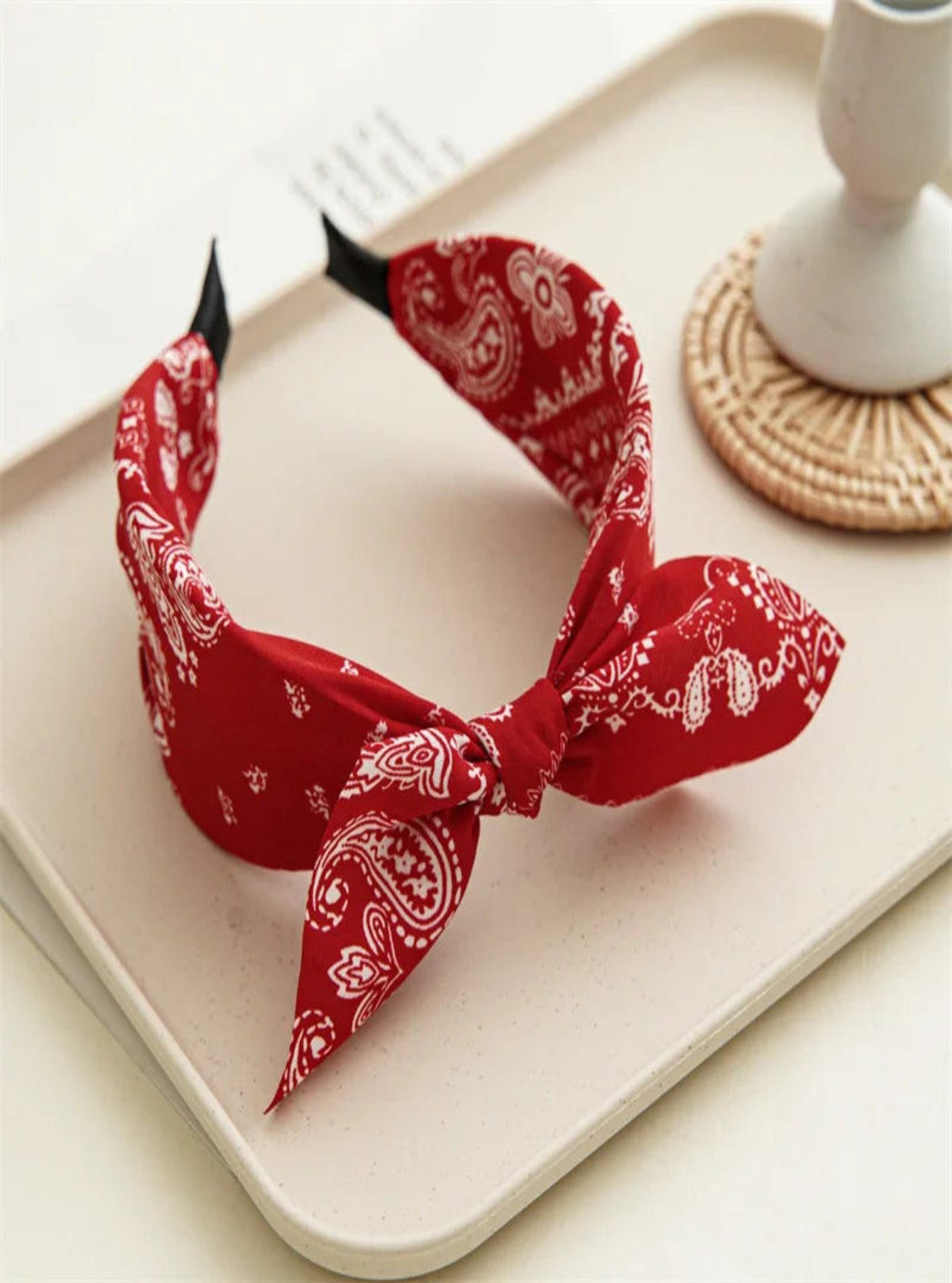 Red bandana with white patterns on a beige tray