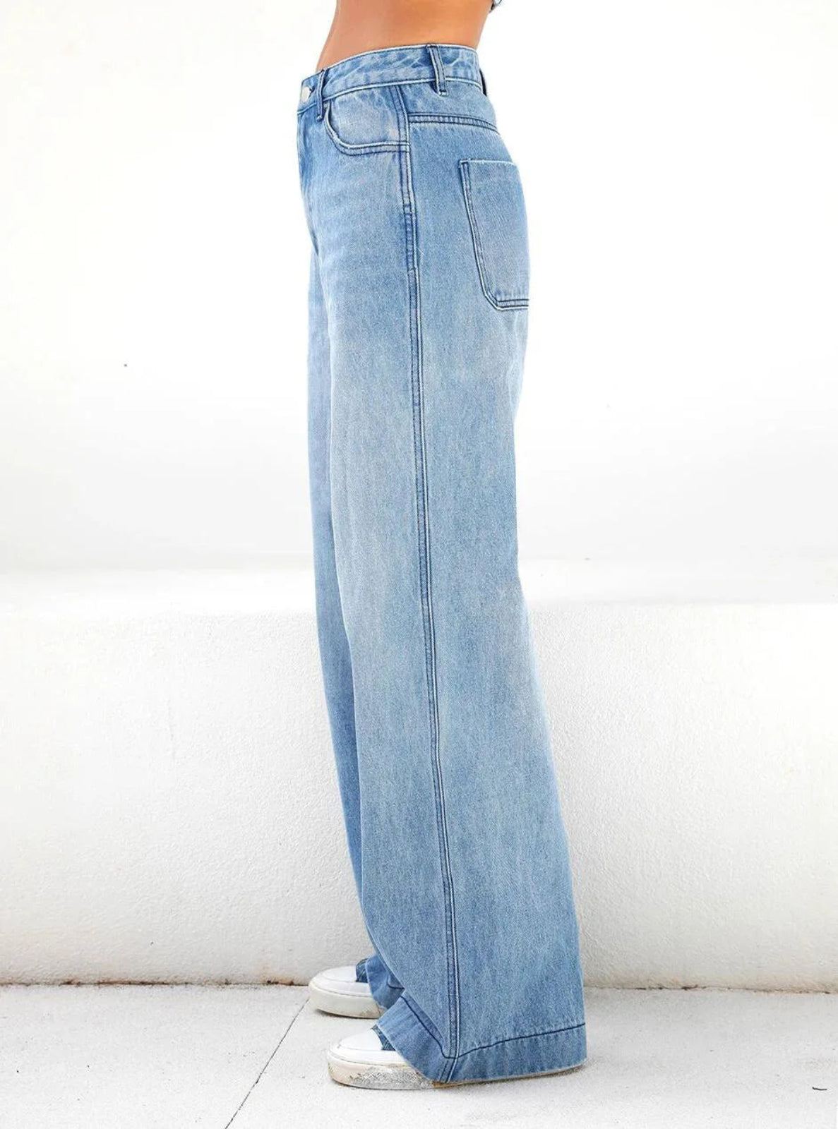 Light blue jeans worn by a person on a white background