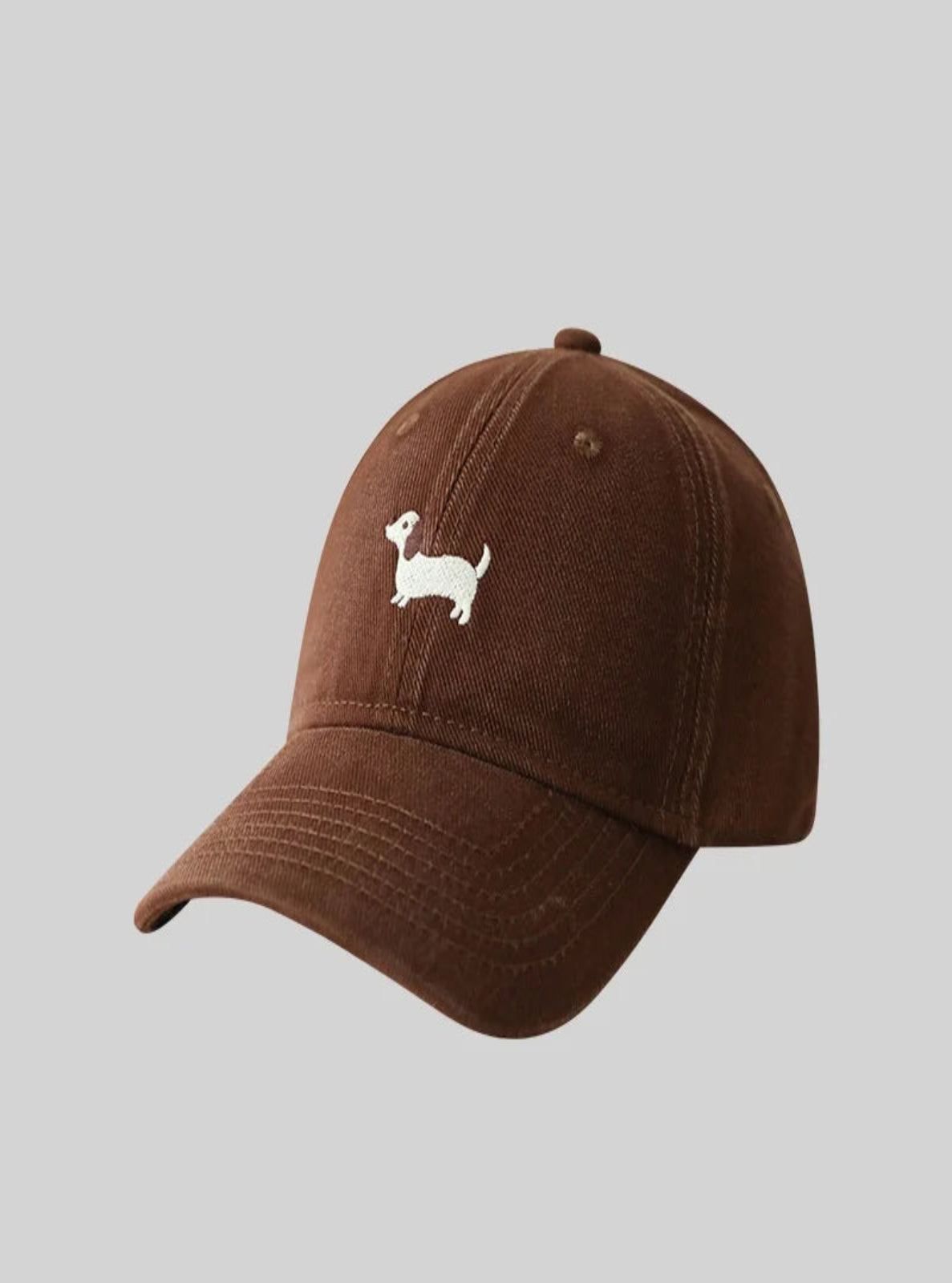 Brown baseball cap with a small white dog illustration on a gray background