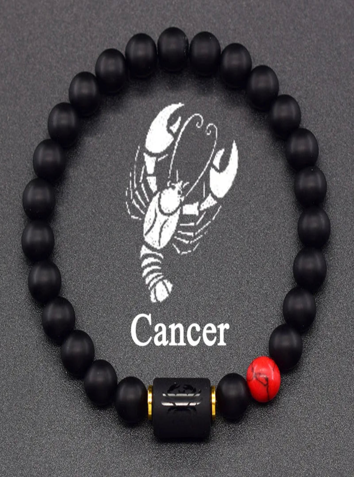 Black beaded bracelet with Cancer zodiac symbol on a dark background
