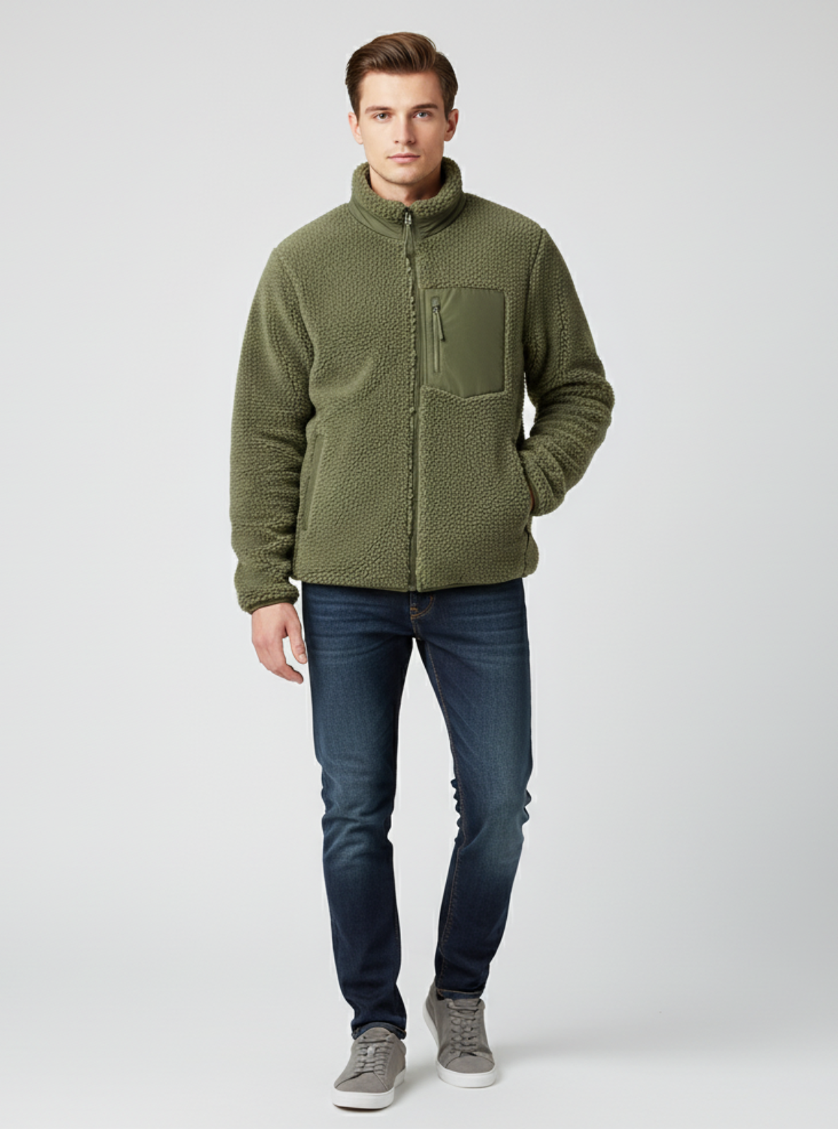 Man wearing a green fleece jacket and blue jeans on a white background