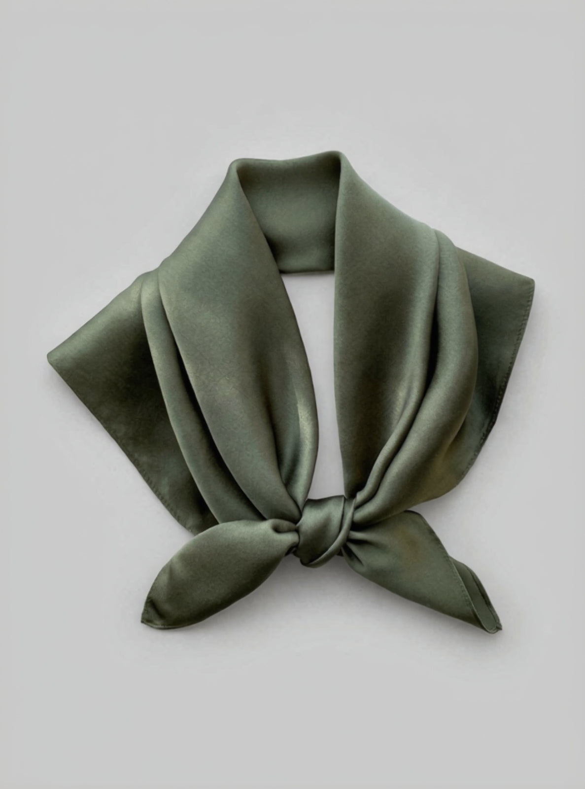 Green satin scarf tied on a light gray background
