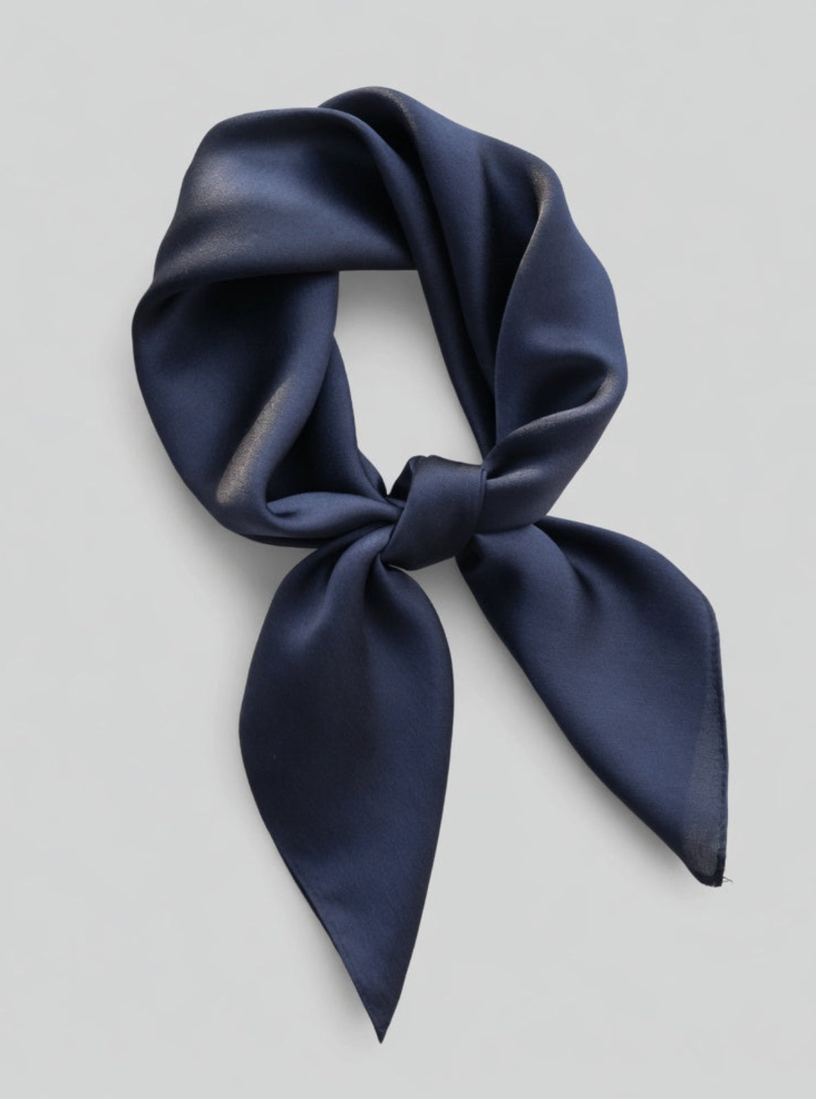 Navy blue silk scarf on a light gray background