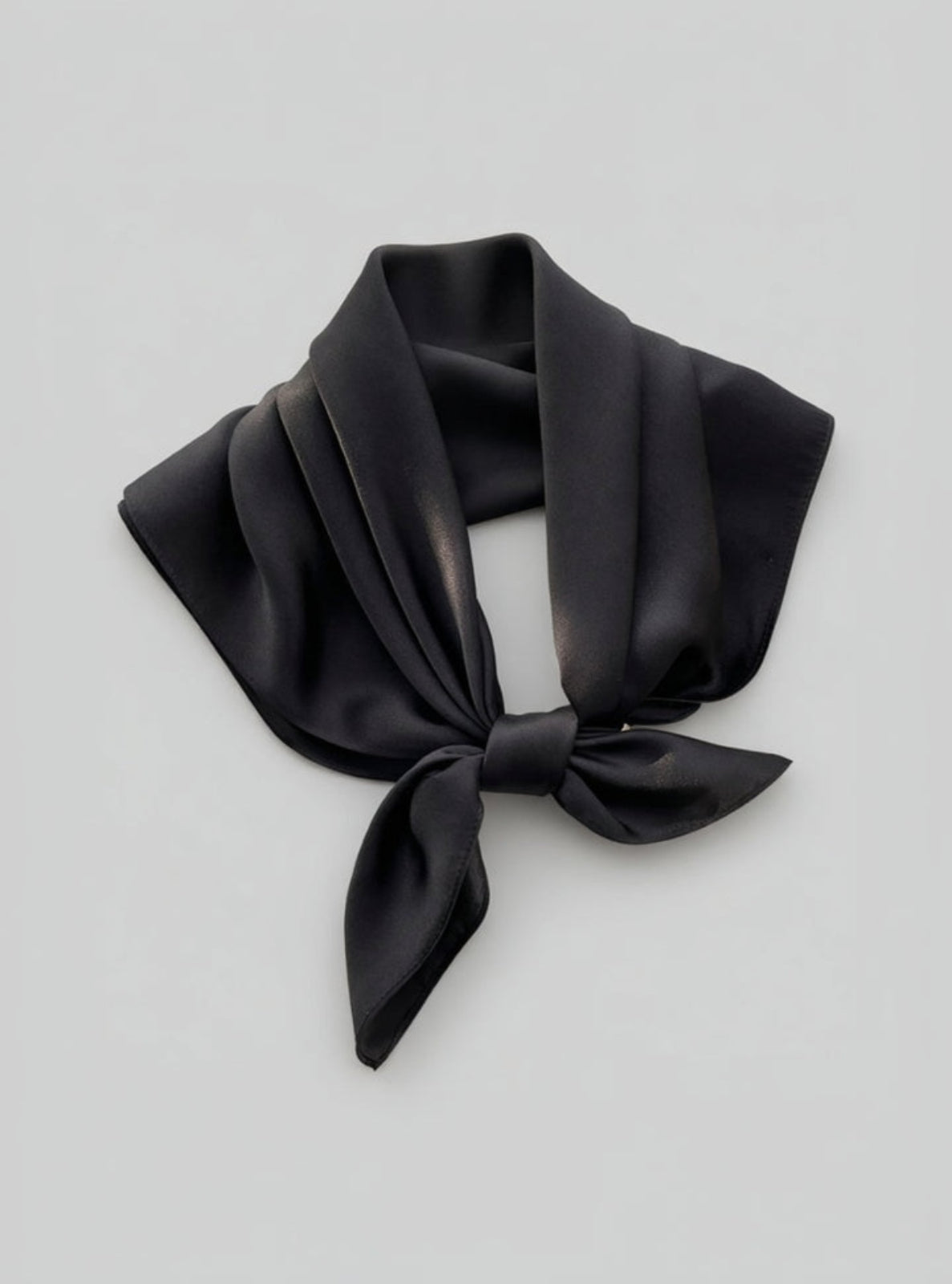 Black scarf tied in a knot on a light gray background