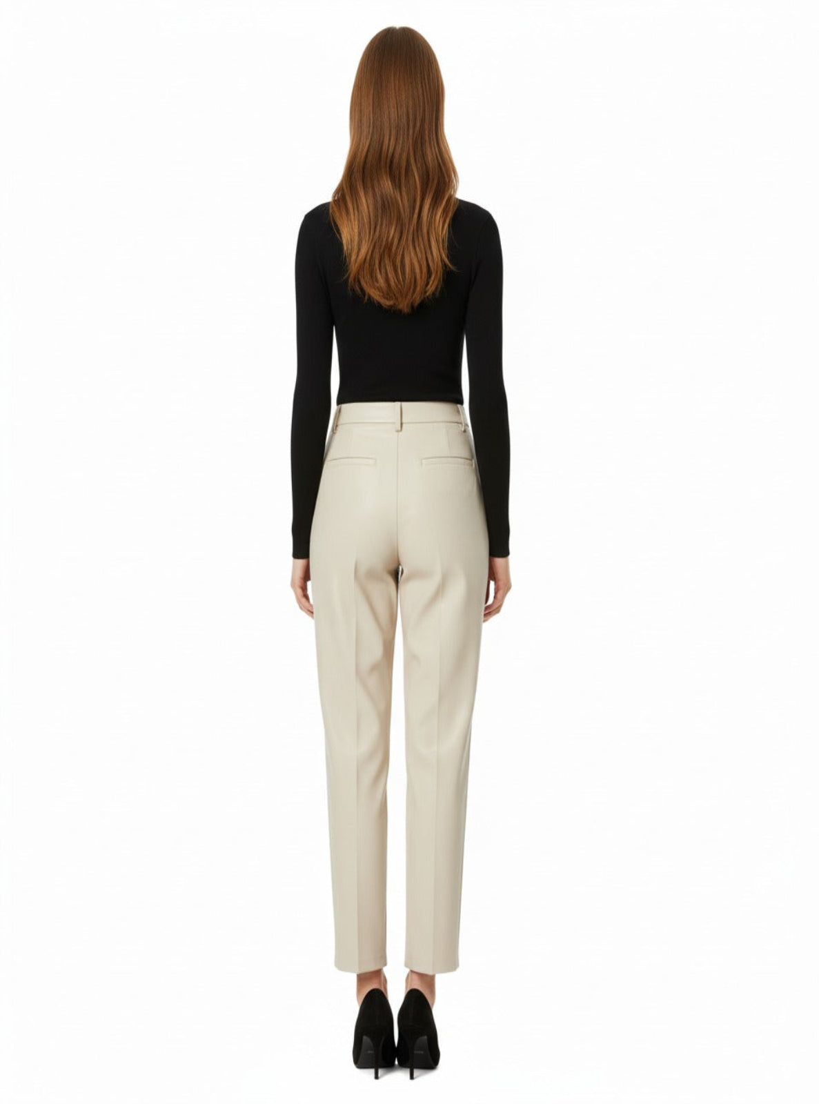 Woman wearing a black top and beige pants on a white background